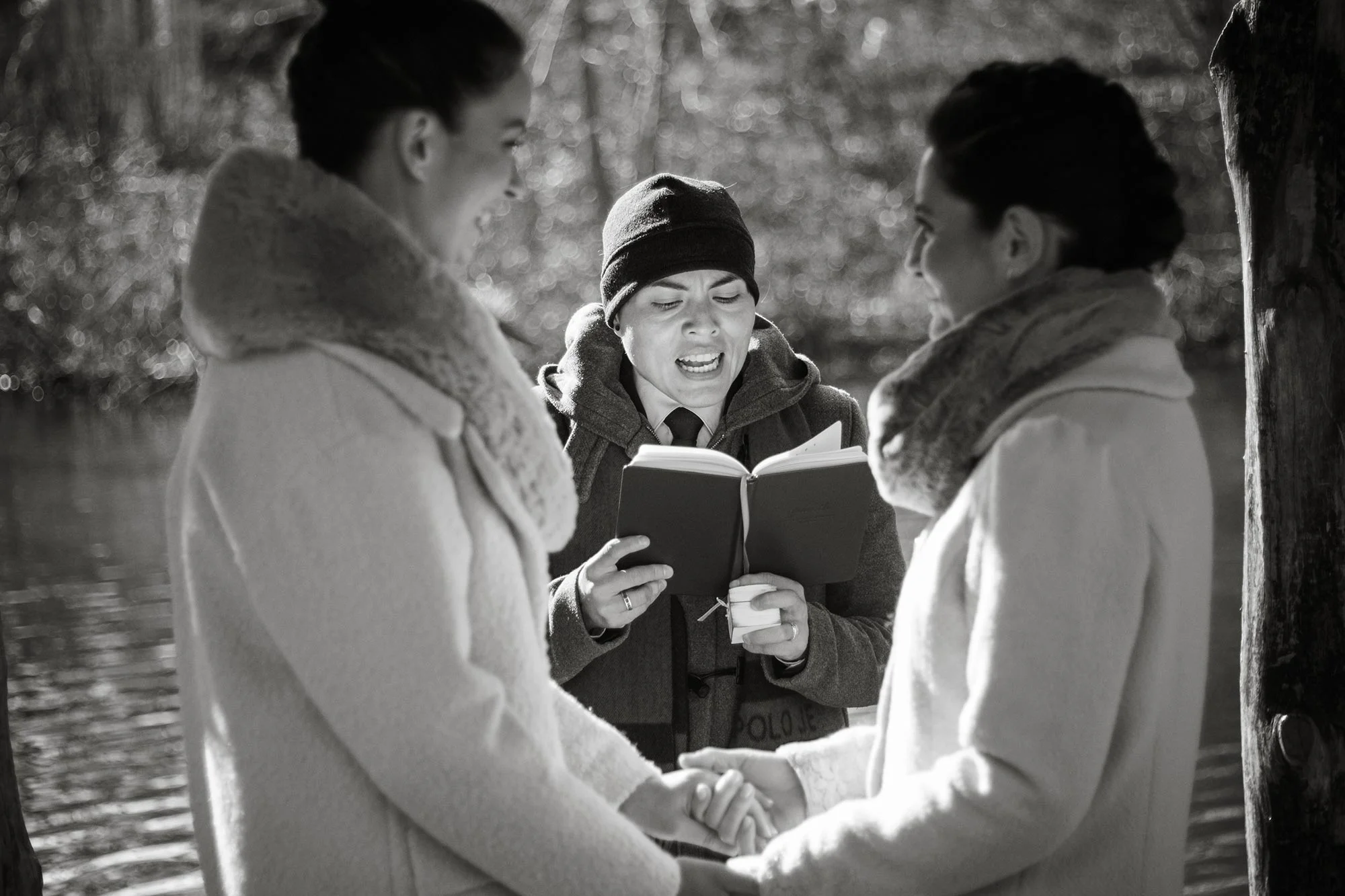 queer irish central park winter elopement kate alison photography officiant karla and brides holding hands by lake