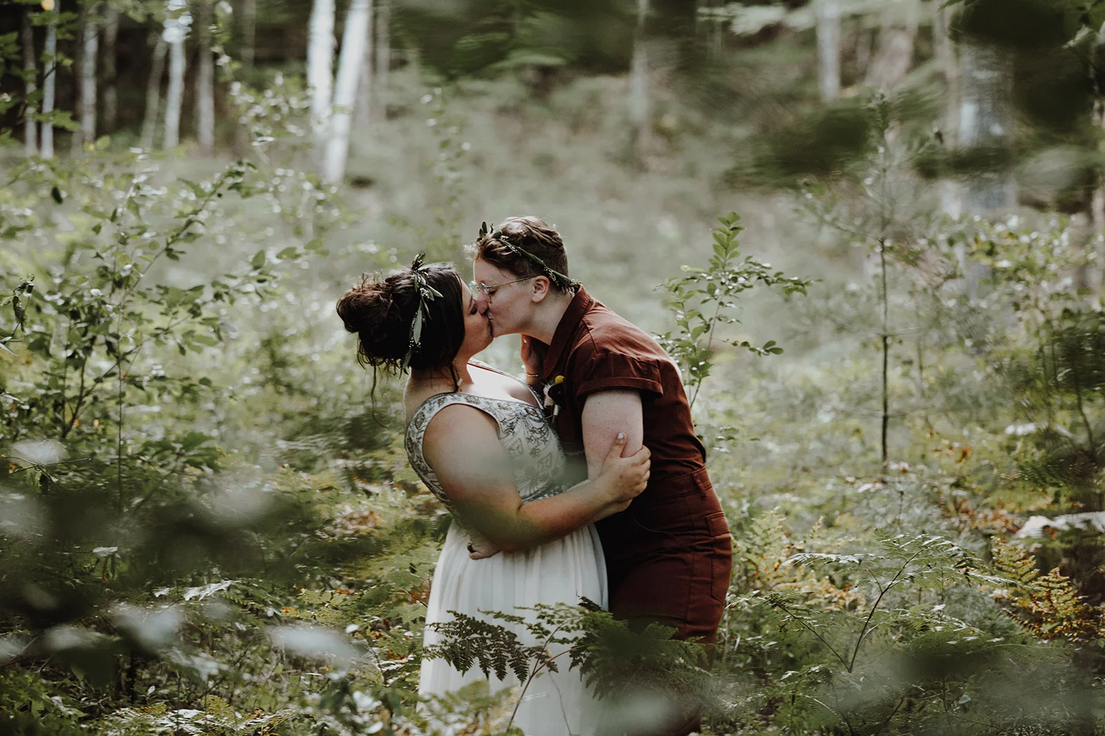 Engaged couple with leaf head bands kissing in a forest Robyn Nicole Film + Photo Portland Maine