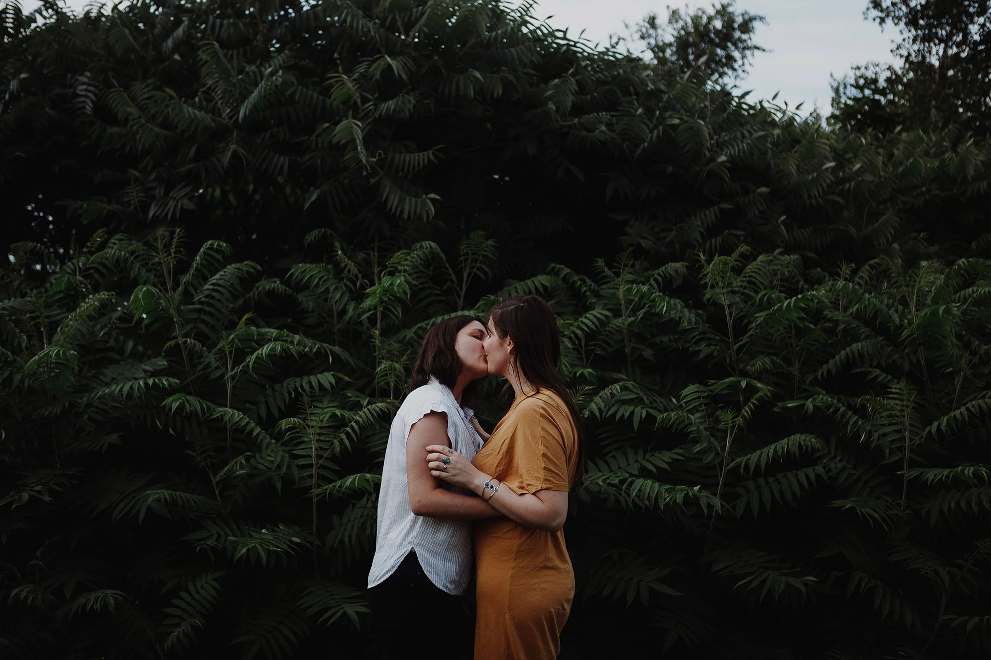 Engaged couple kissing before a forest of ferns Robyn Nicole Film + Photo Portland Maine