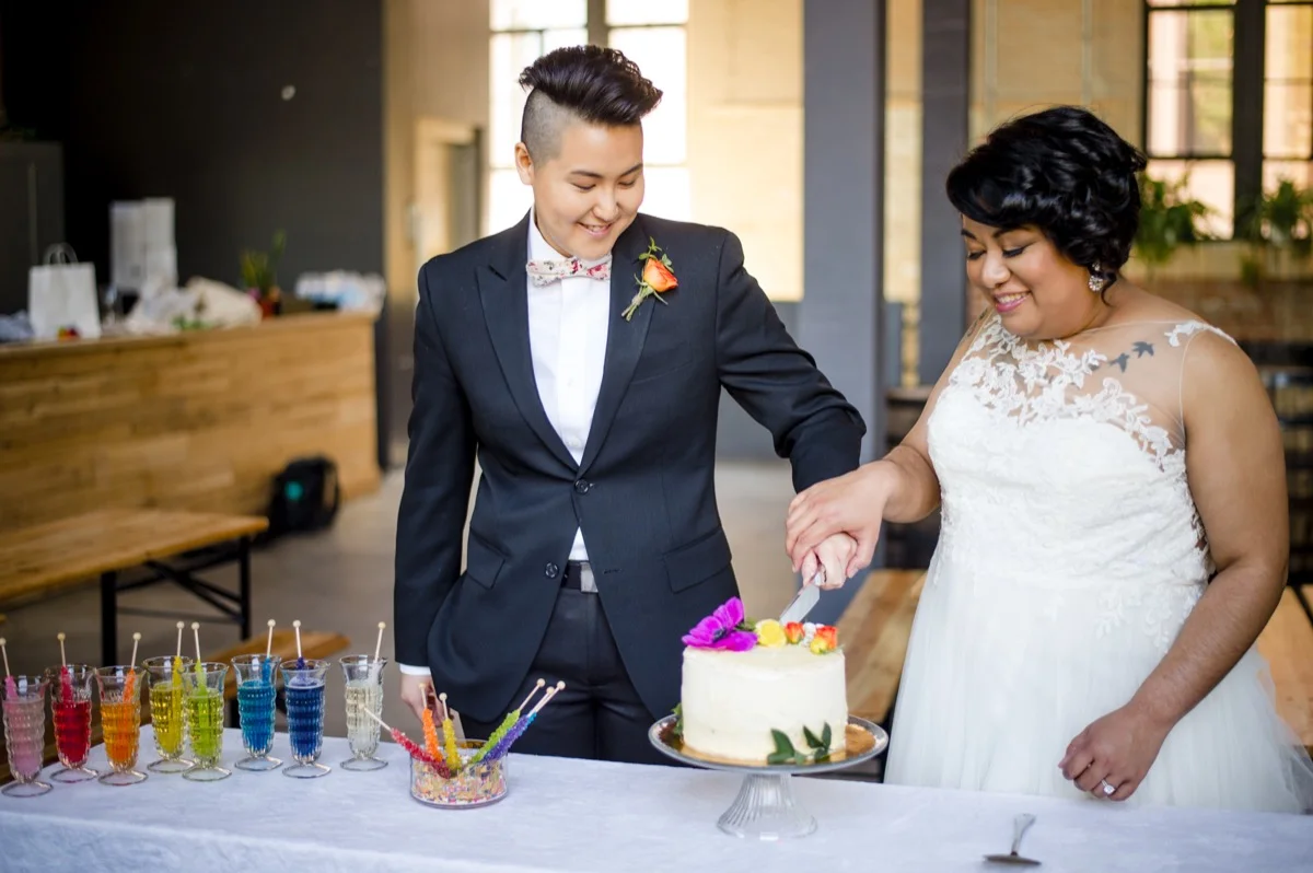 RAINBOW QUEER WEDDING INSPIRATION MICHELLE SCHAPIRO, DEANNA NAGLE, couple cutting cake