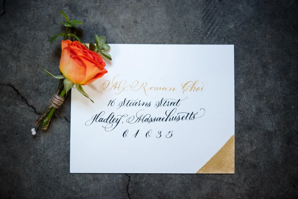 RAINBOW QUEER WEDDING INSPIRATION MICHELLE SCHAPIRO, DEANNA NAGLE, envelope with orange flower boutonniere