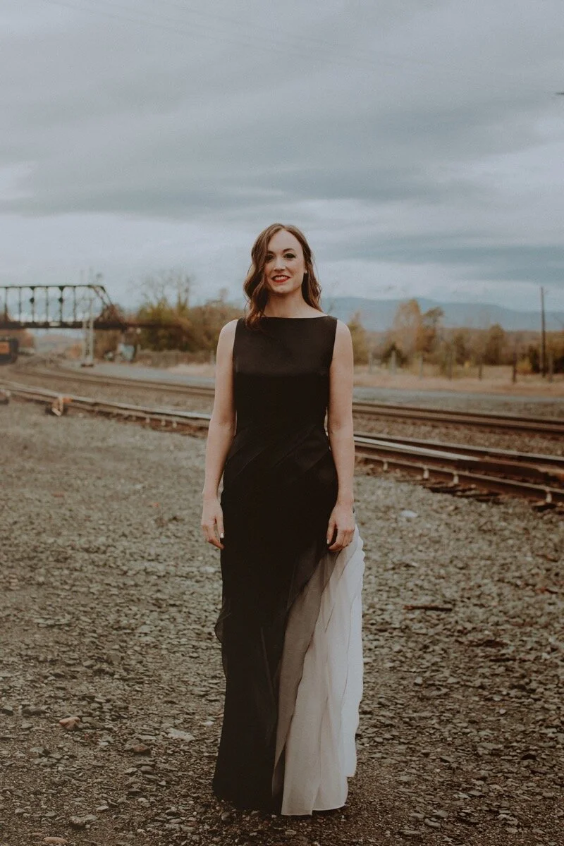 bride in black and white dress near old train tracks before industrial wedding ceremony in Hudson New York Chellise Michael Photography