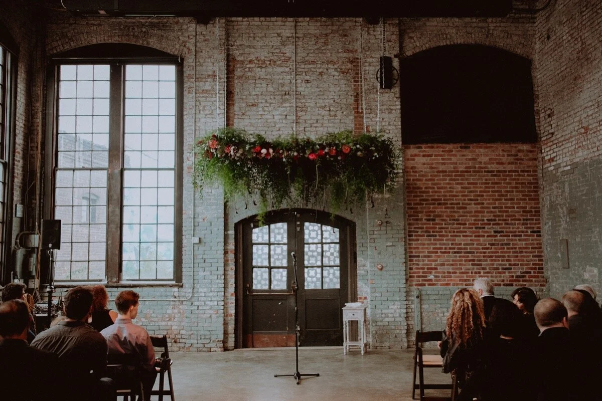 Floral canopy over ceremony spot at industrial wedding venue in Hudson New York Chellise Michael Photography
