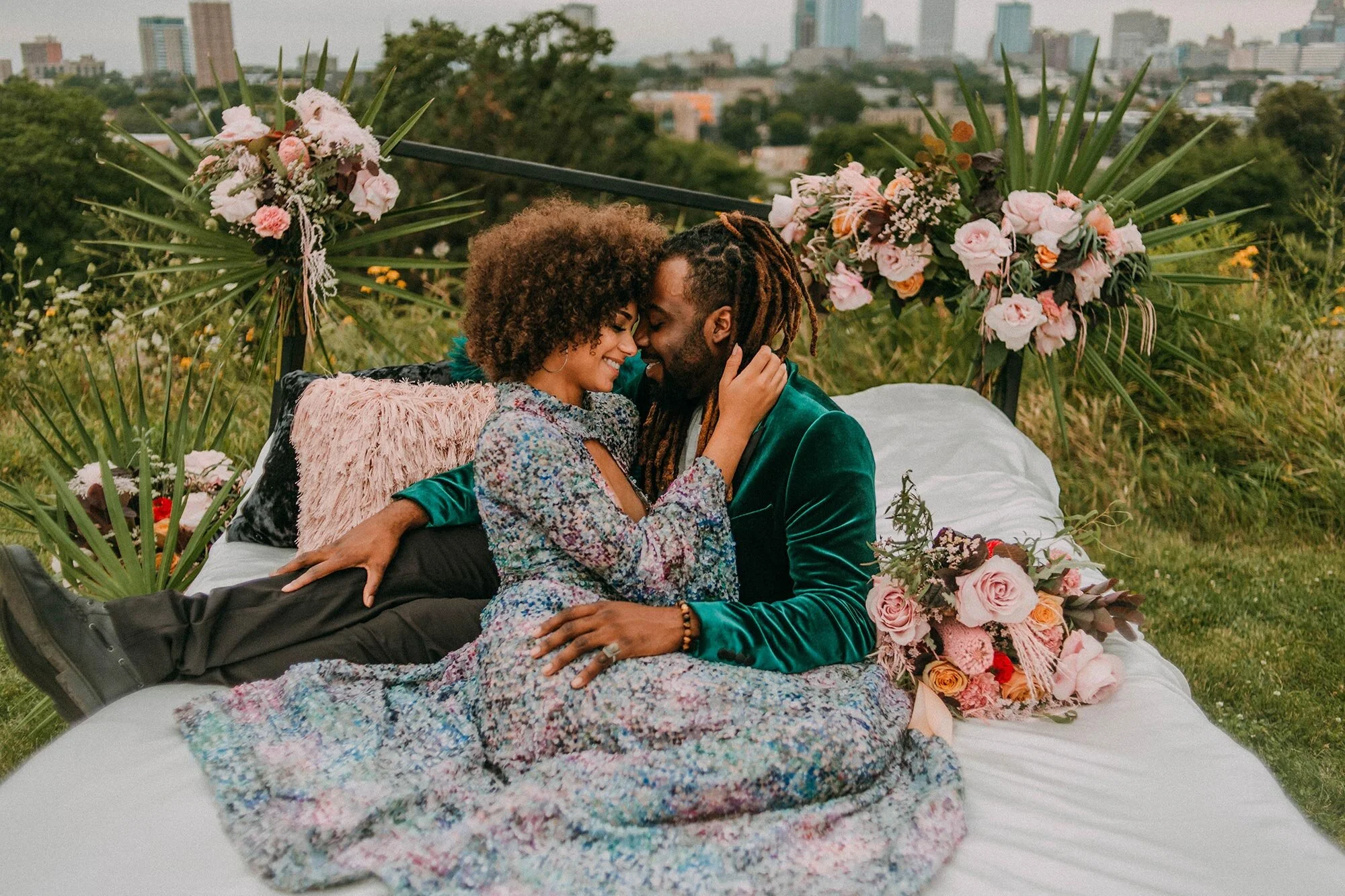 bride in sequin dress and groom in green velvet suit embraces on bed surrounded by grass and flowers wedding elopement inspiration Milwaukee A Lentz Photography