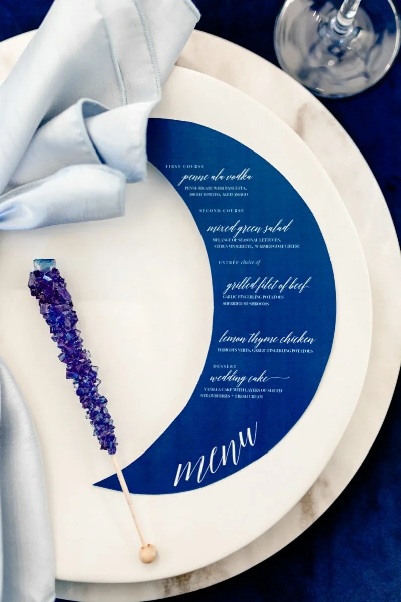 Celestial and Geode wedding inspiration in Winston Salem NC showing cobalt blue and gold moon menu and table setting Ariel Kaitlin Photography