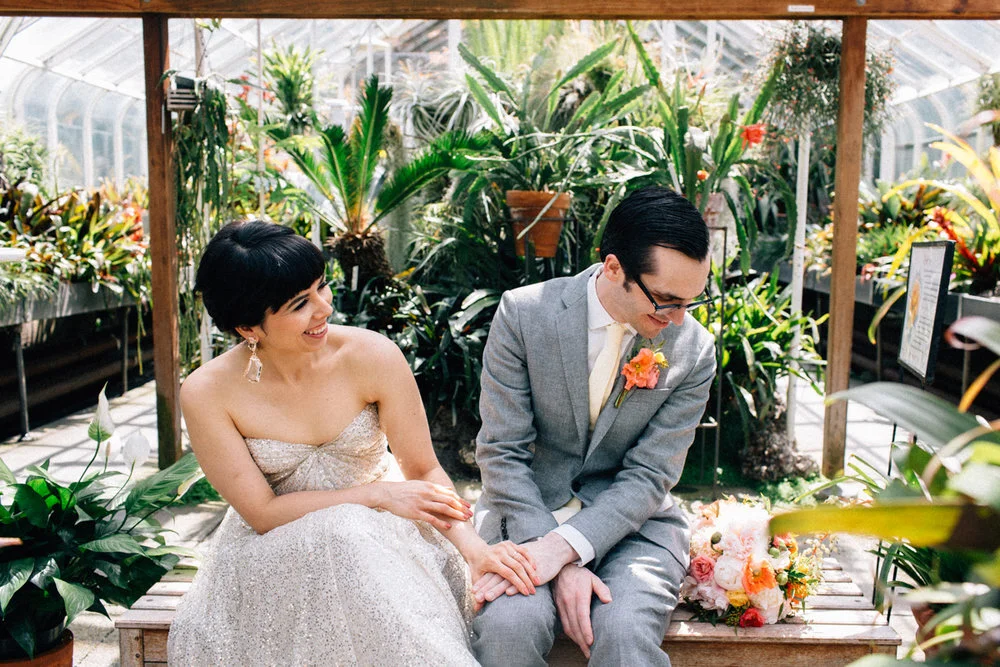 Marriers in gray wedding dress and suit smile during greenhouse first look in Seattle Fuck Yeah Weddings