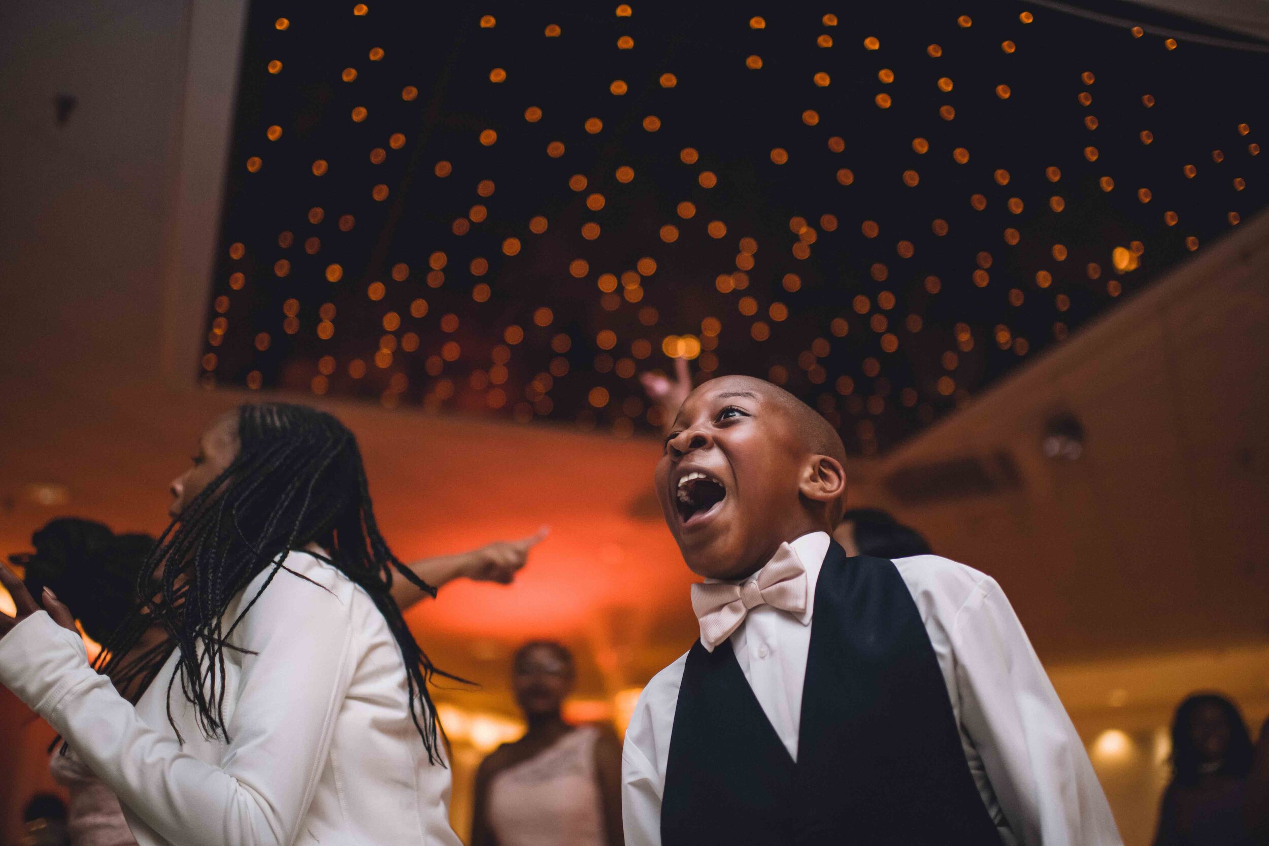 Child laughs on dance floor during wedding reception by Teresa Johnson Connecticut Wedding Photographer