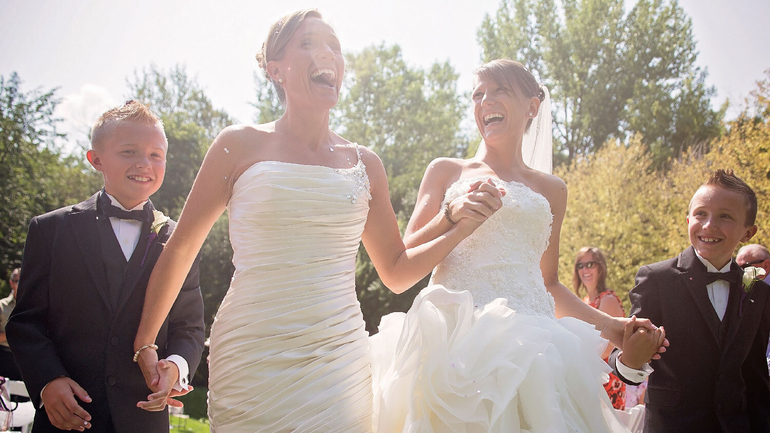 Two brides hold hands after their wedding ceremony Teresa Johnson Rhode Island Wedding Photographer