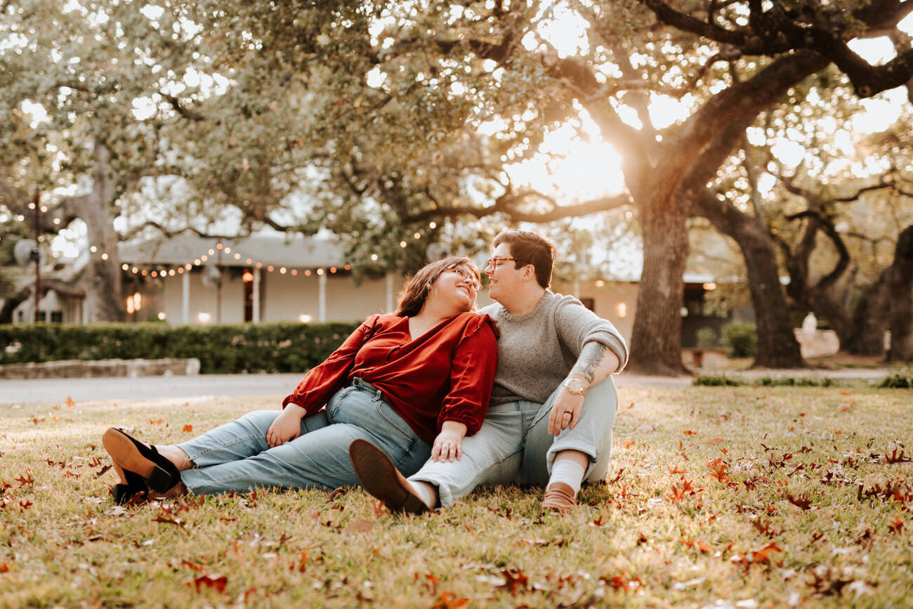 Engaged couple sit under tree during fall photo session Diana Ascarrunz Austin Wedding Photographer