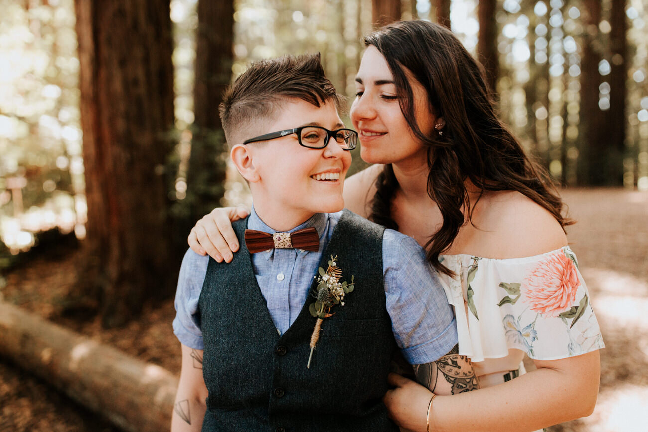 Engaged LGBTQ+ couple lean in for kiss under tree Diana Ascarrunz Austin Wedding Photographer