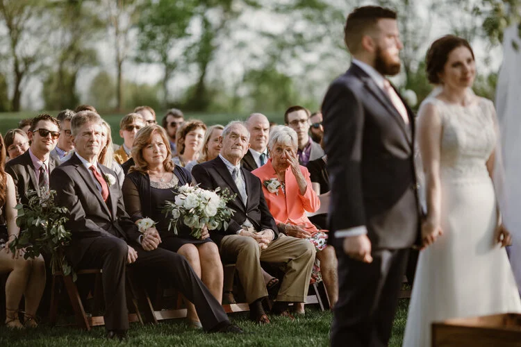 Couple holding hands during wedding ceremony as family wipes away tears Richmond Virginia Betty Clicker Photography