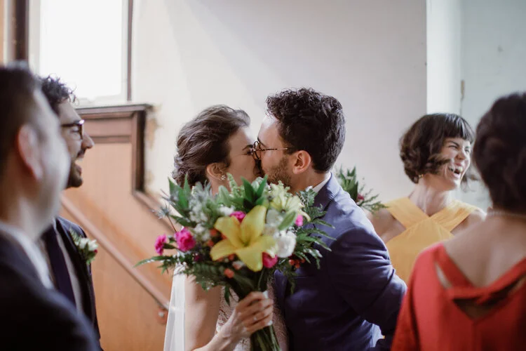 Bride and groom share a kiss behind bouquet at reception Richmond Virginia Betty Clicker Photography