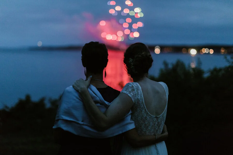 Newlyweds look across lake at fireworks as sun sets on their wedding day tears Richmond Virginia Betty Clicker Photography