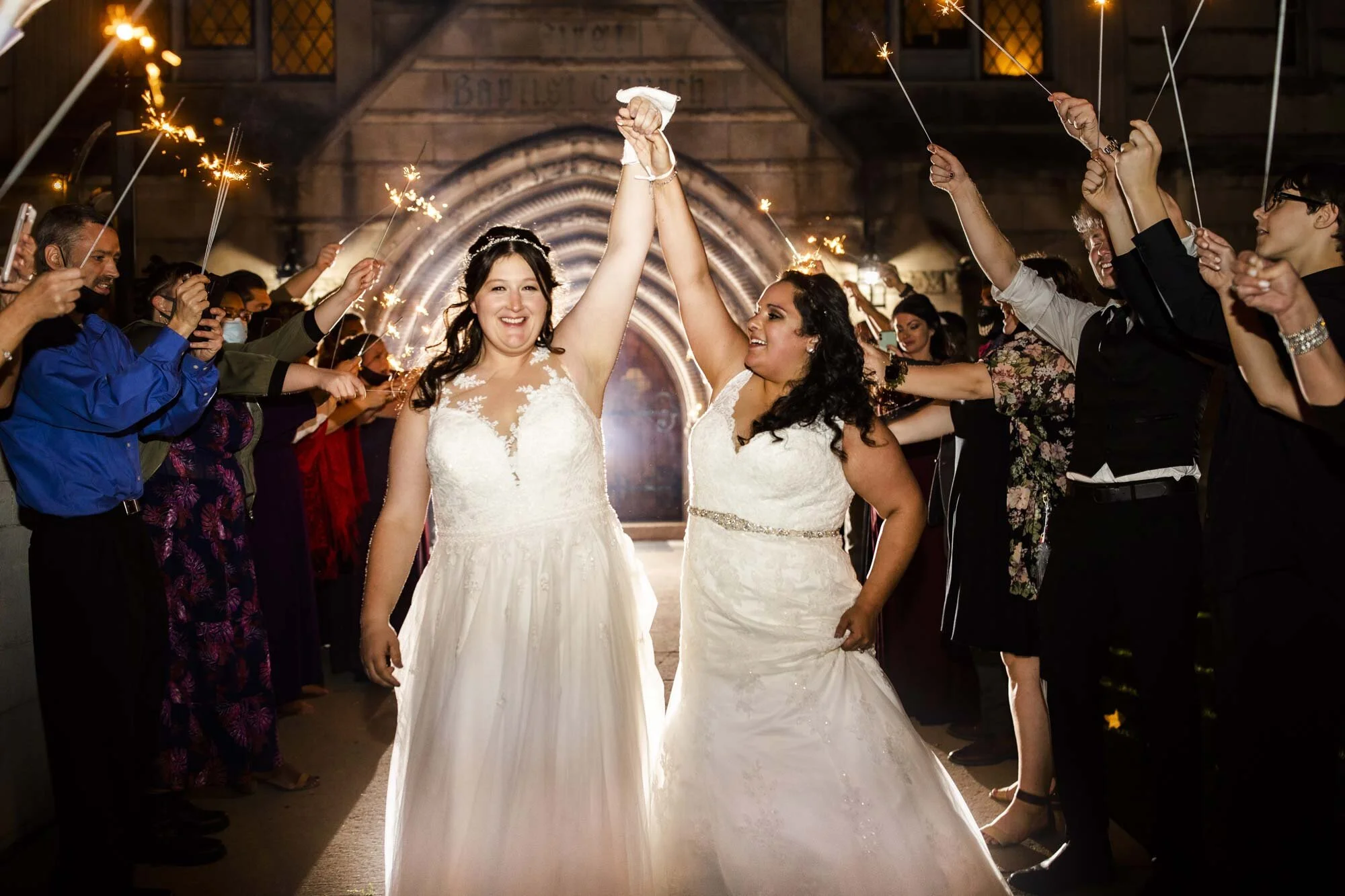 Newlywed couple hold hands in the air during wedding reception sparkler exit in Ohio Amy Ann Photography