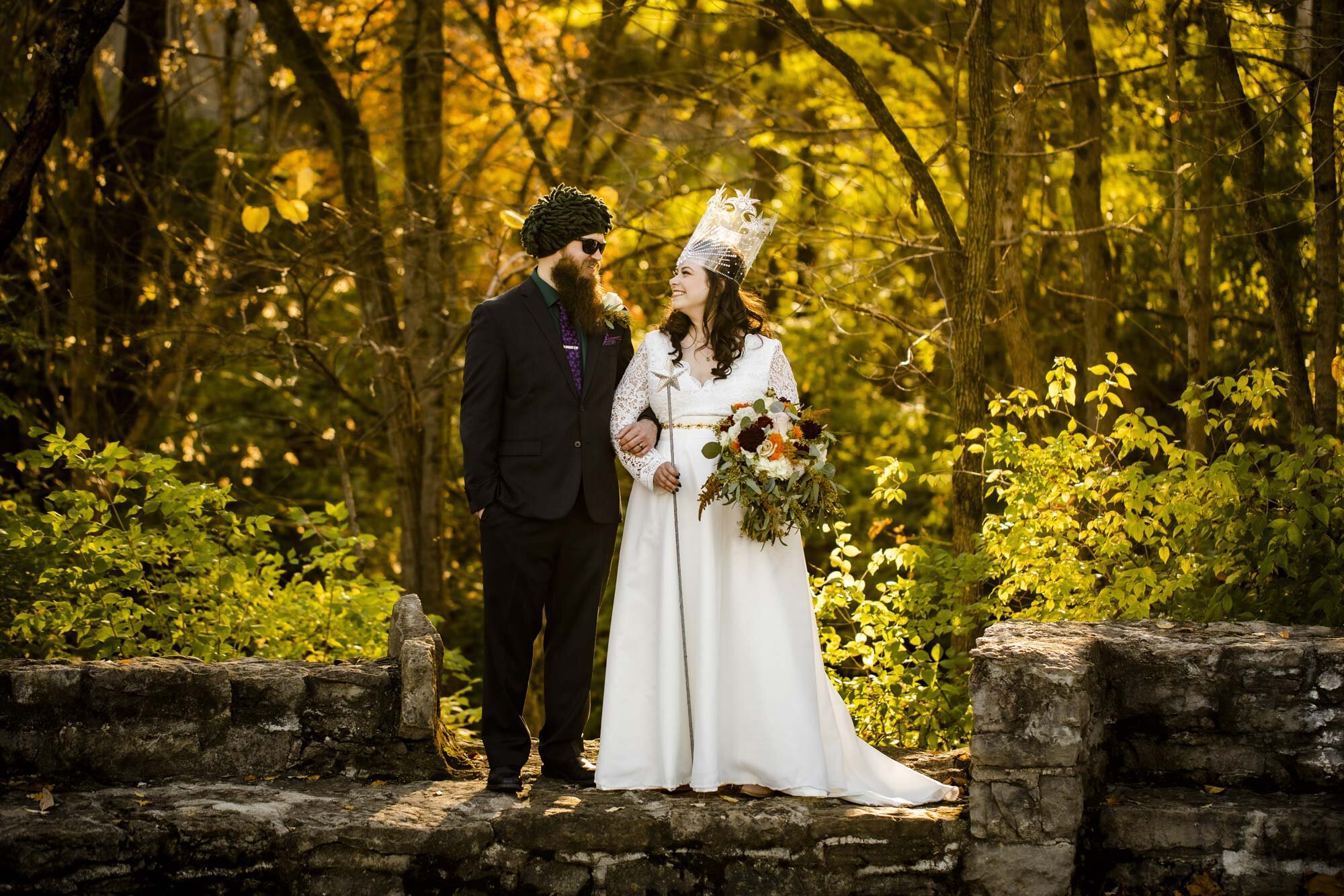 Couple hold hands and look at each other in suit and Glenda the good witch gown during autumn wedding in Ohio Amy Ann Photography