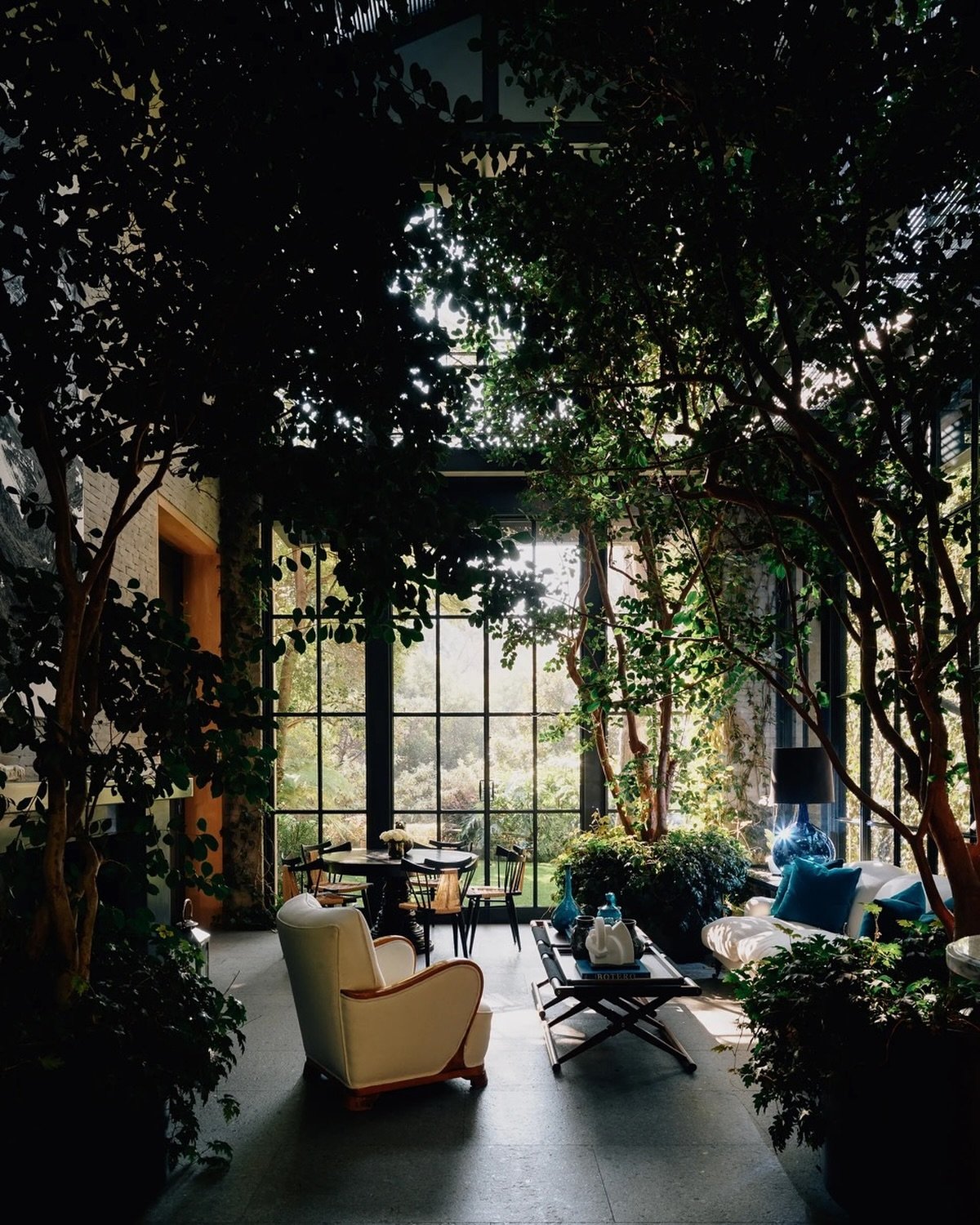 As appeared in AD. &ldquo;It&rsquo;s our favorite place in the house,&rdquo; says Lina Botero of the lush winter garden, where a Biedermeier armchair sits alongside a sofa upholstered in Ralph Lauren linen and cocktail tables by Richard Wrightman. In