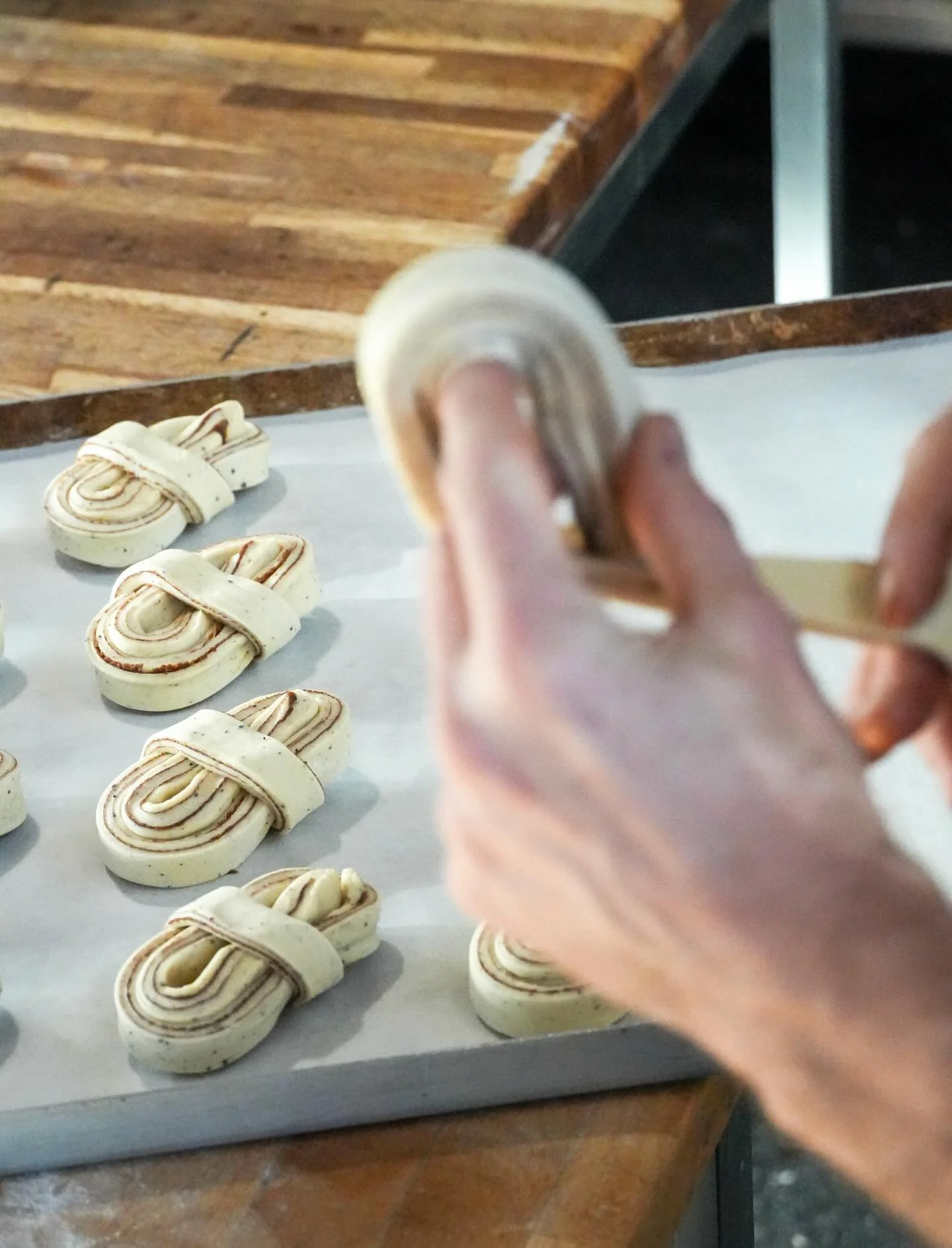 Flour-dusted hands, soft dough and a generous cinnamon filling tucked into every twist - each bun shaped by hand and lined up, ready for the oven. Mornings at S&ouml;derberg Bakery 🌅