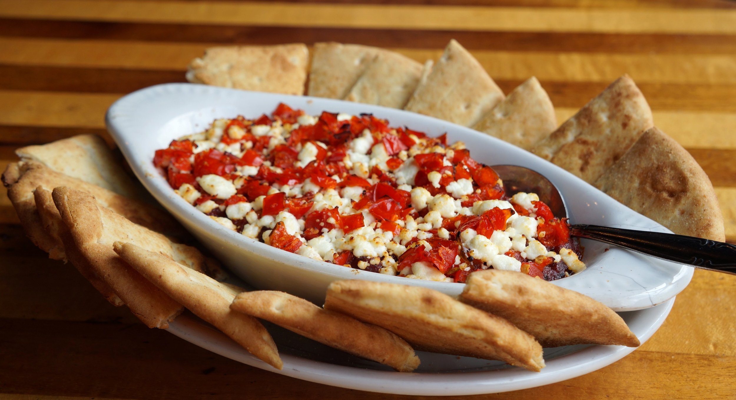 Goat Cheese Marinara - house made marinara topped with goat cheese and tangy peppadew peppers. Served with toasted pita bread for dipping.