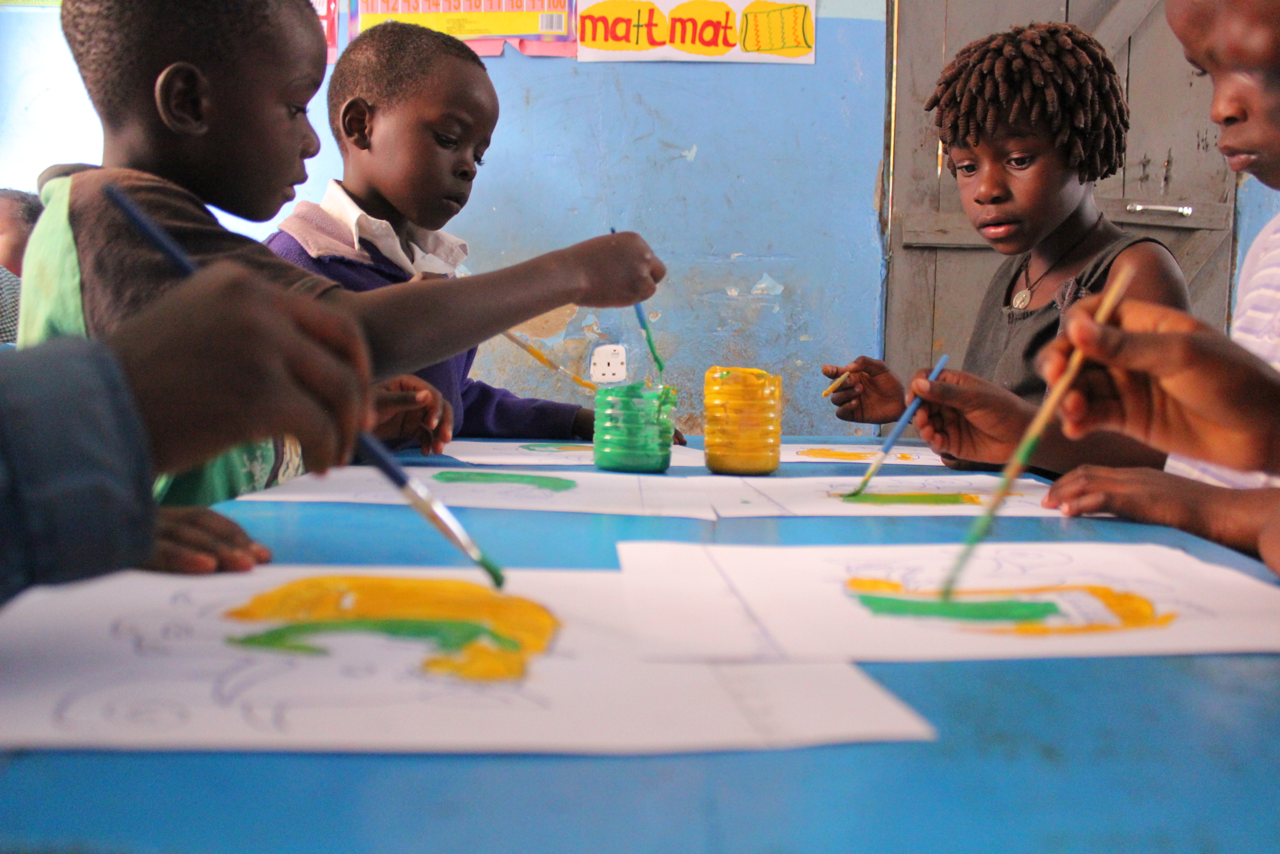 Young children painting in the catch-up class