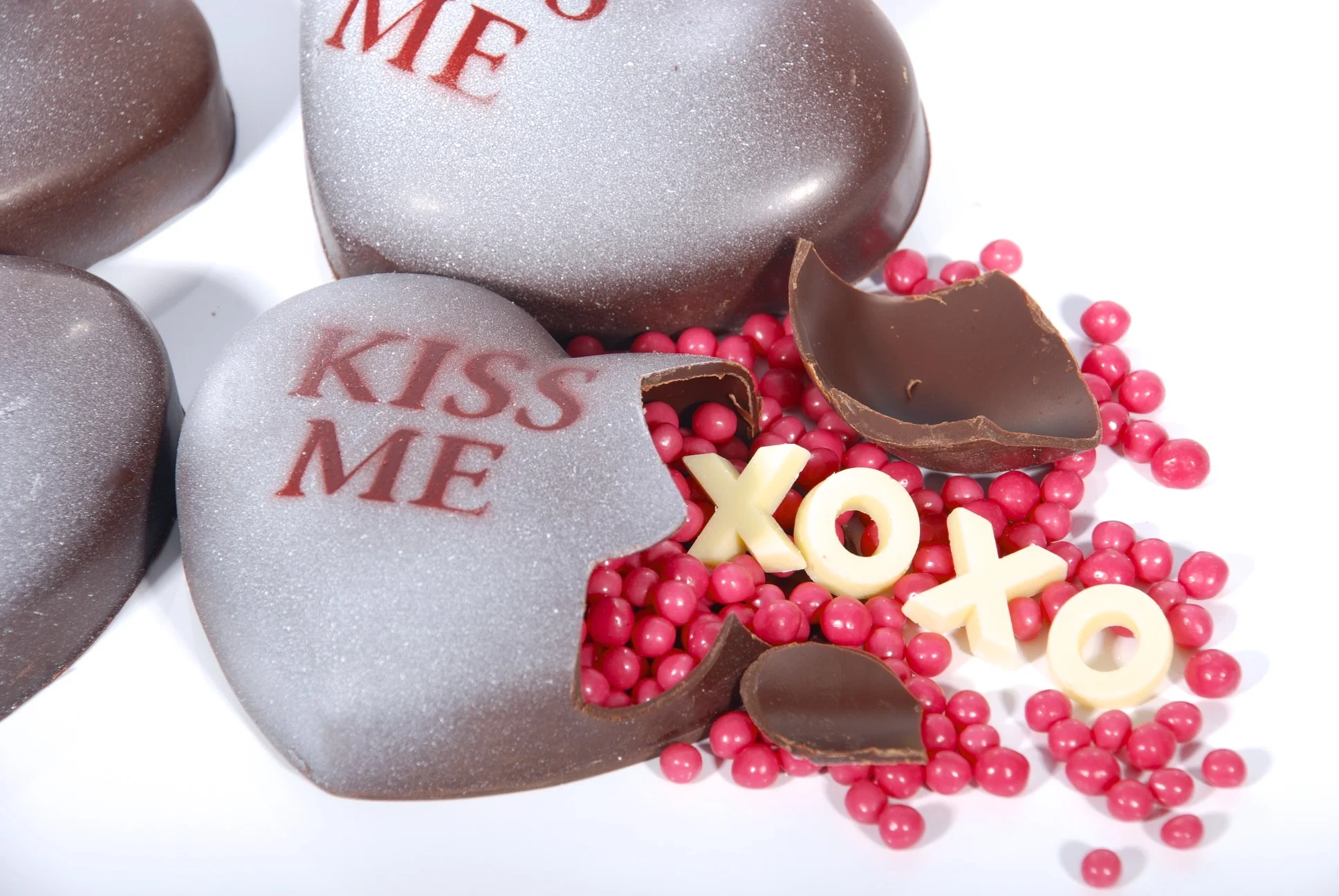 Heart-shaped chocolate "rattle" - break it open and "hugs" & "kisses" spill out, along with strawberry crisp pearls. Surprise!