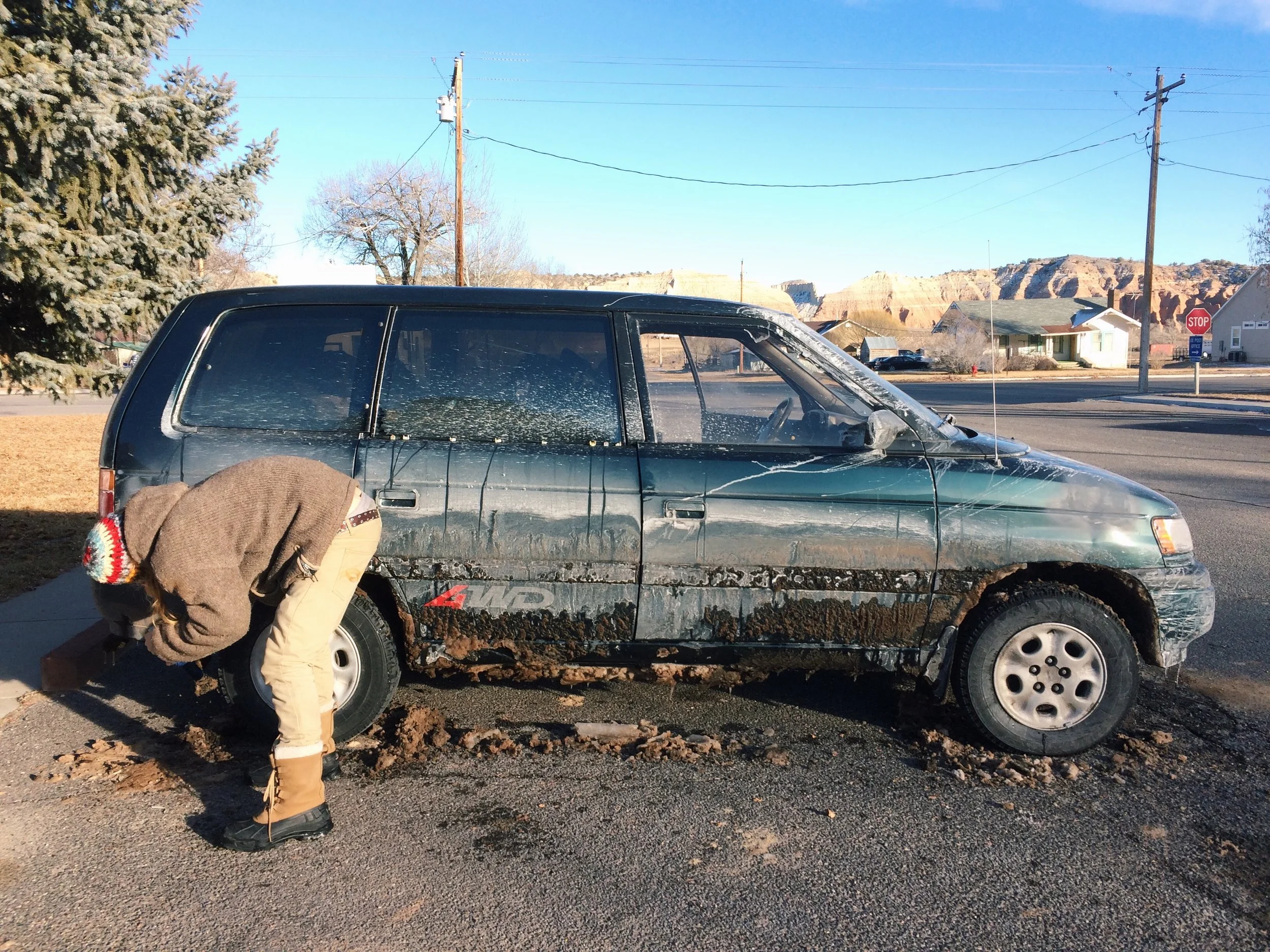 Scraping out Vanny's wheel-well, after tackling the Rocky Mountains.