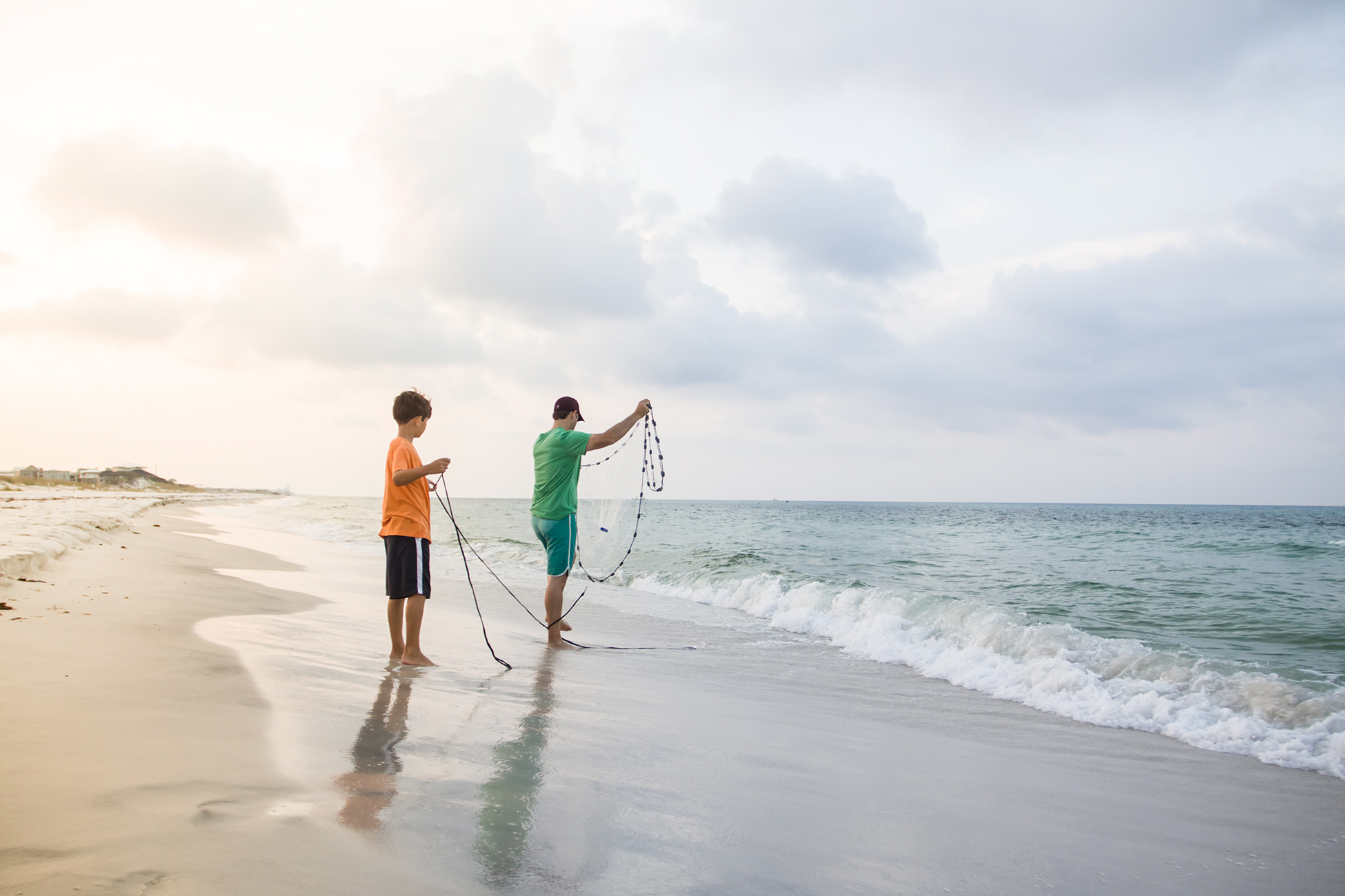 Father and son wielding a bait net.