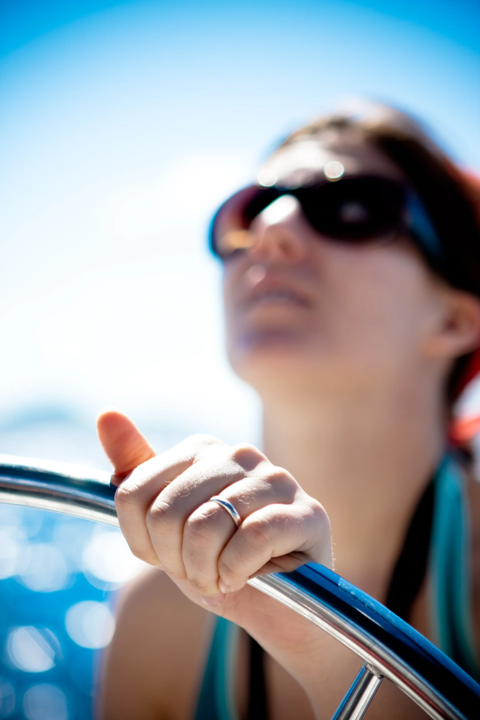Detail of the hand of a female captain as she guides a sailboat from the helm.