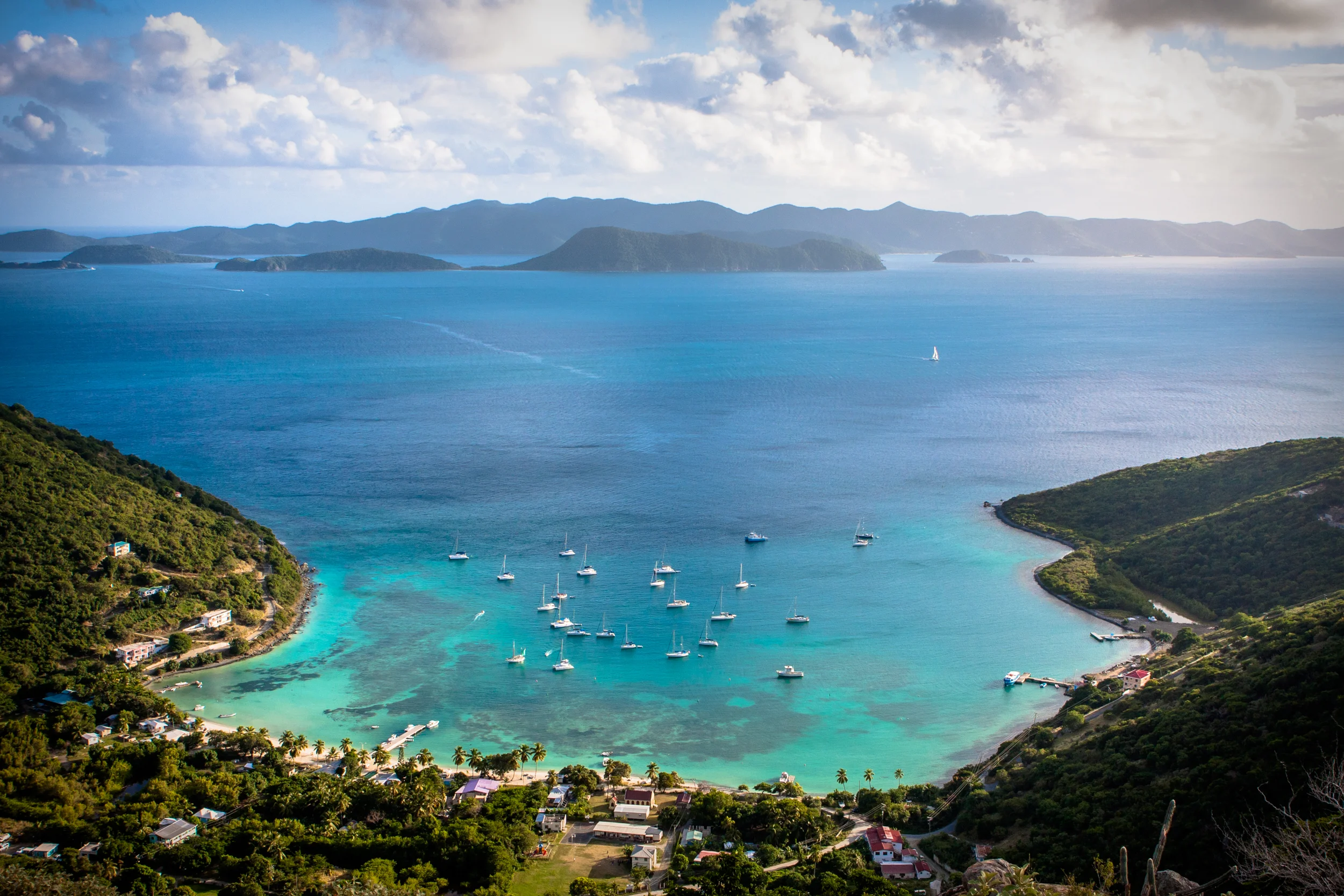 Aerial view of Great Harbor on Jost Van Dyke with sailboats, islands and clear Caribbean water.