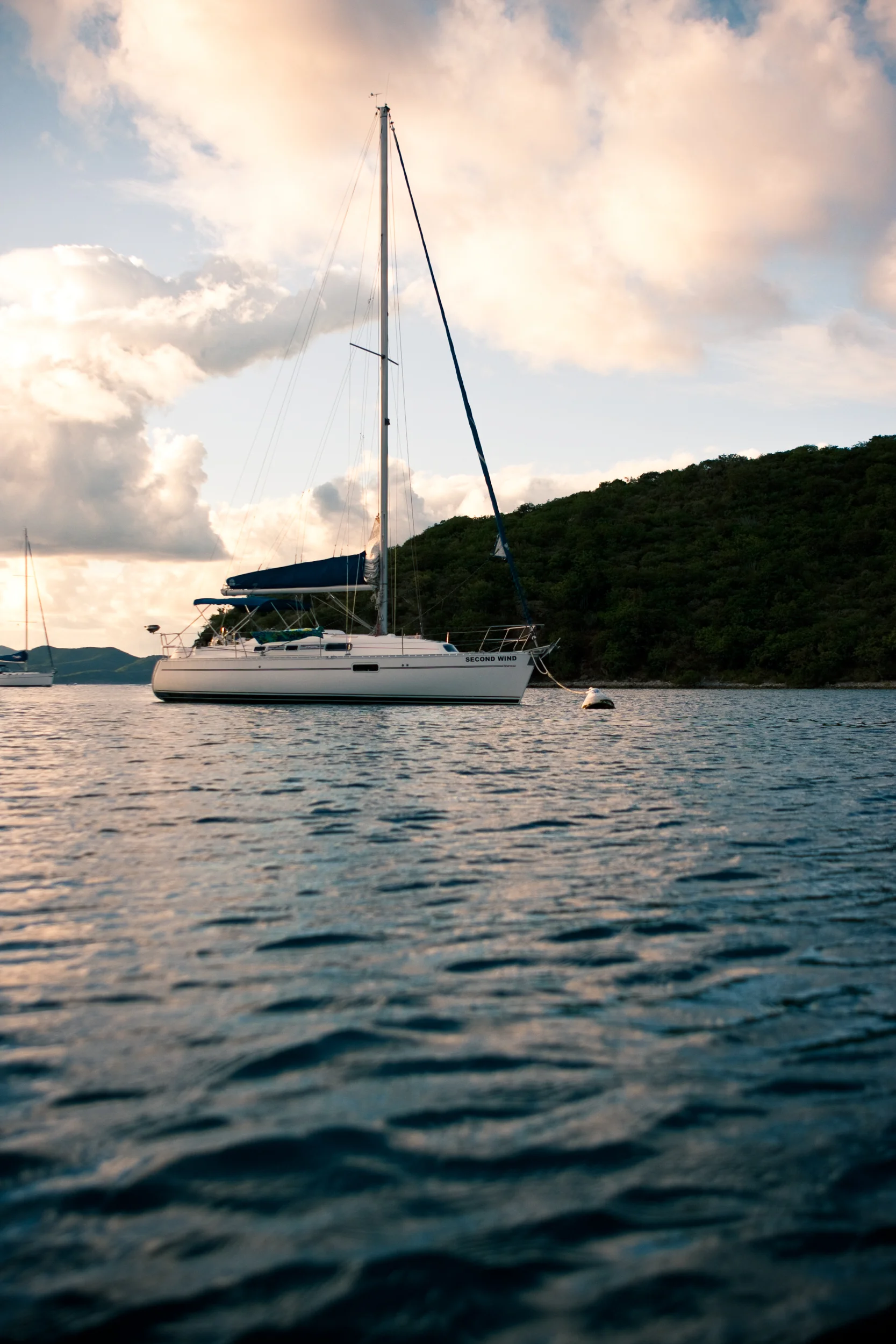 Low angle view of an anchored sailboat as the sunsets behind Caribbean Islands.