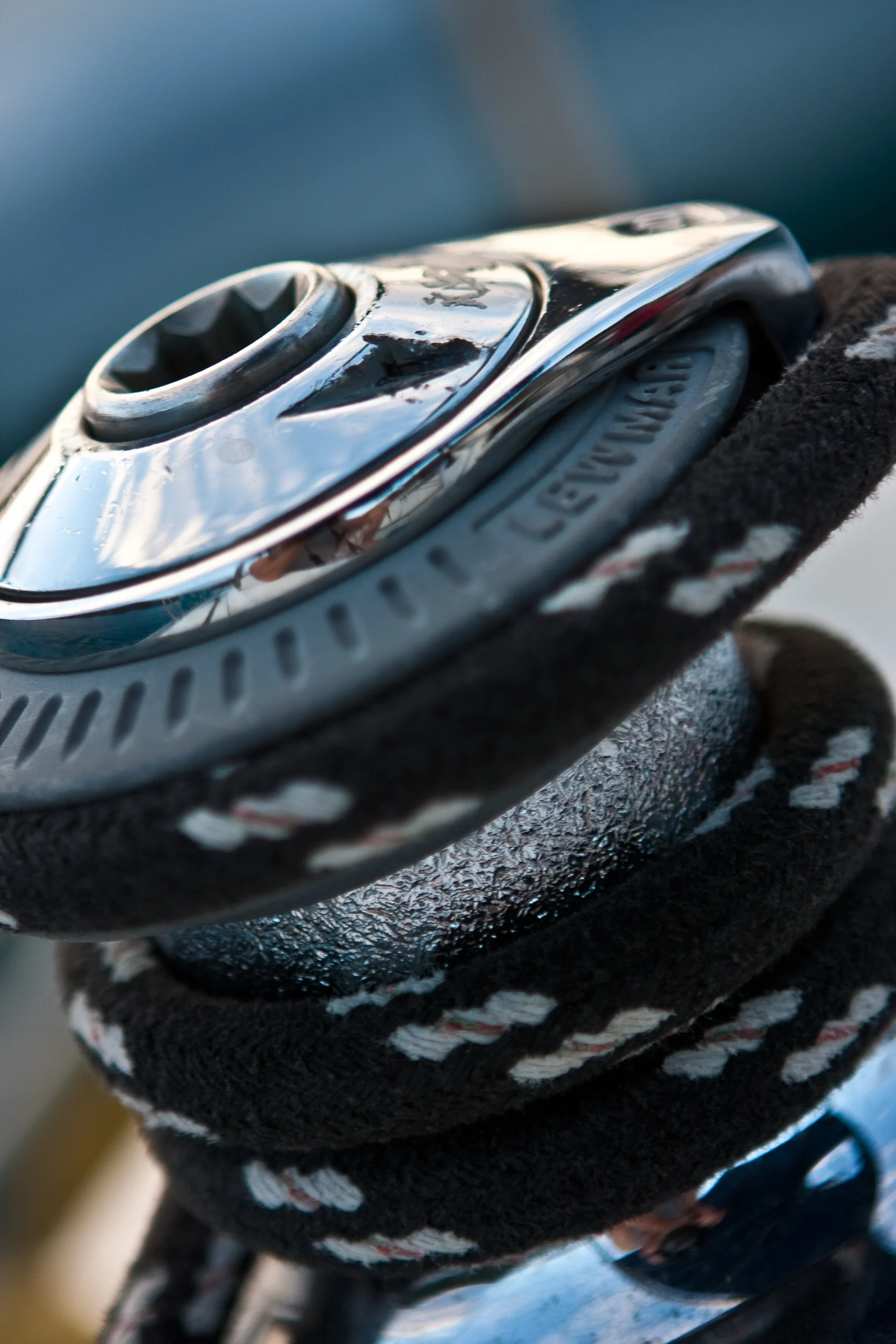 Detail image of a black rope cleated off on a sailboat winch.