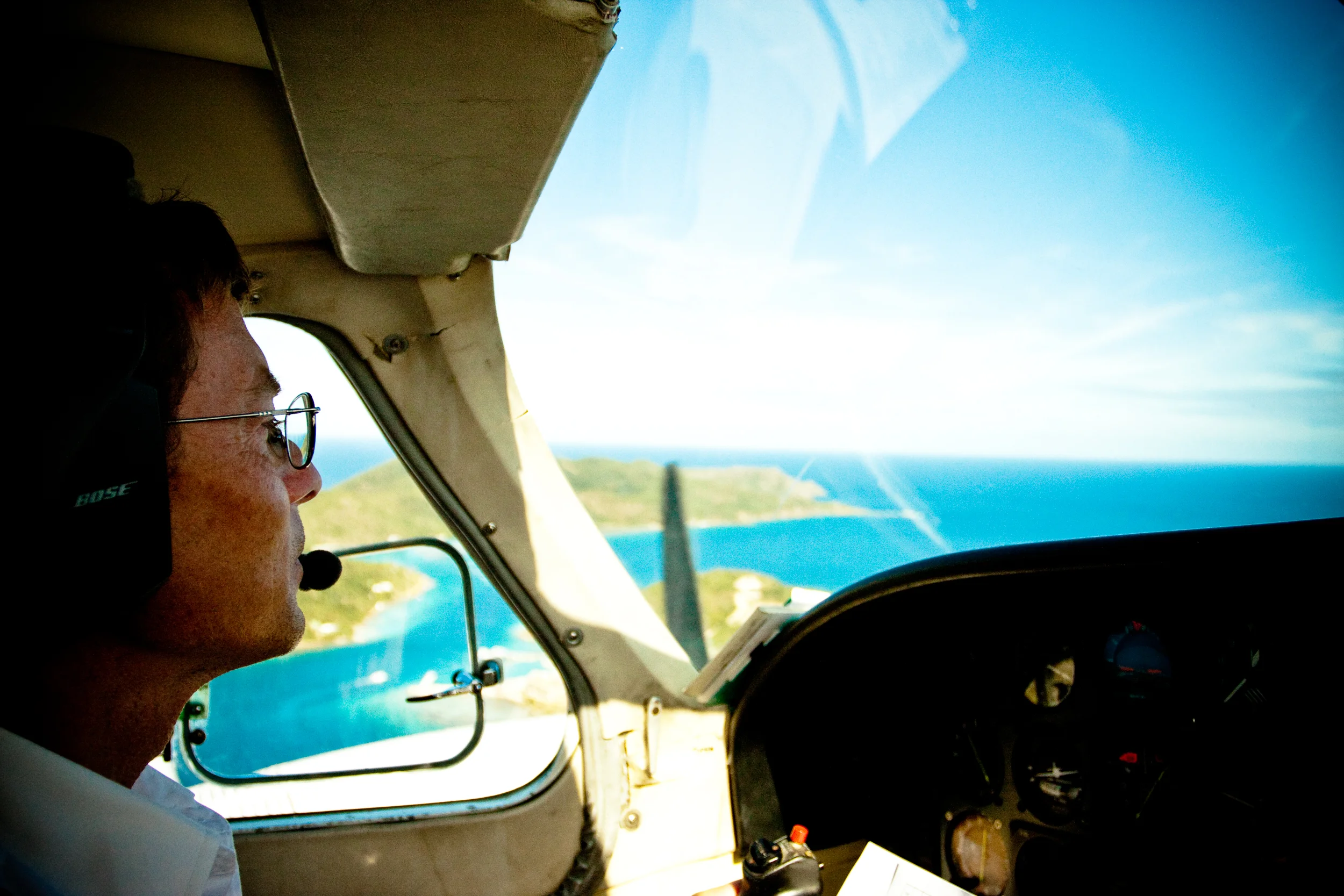 Pilot looks out across blue Caribbean waters during a small inter island flight.