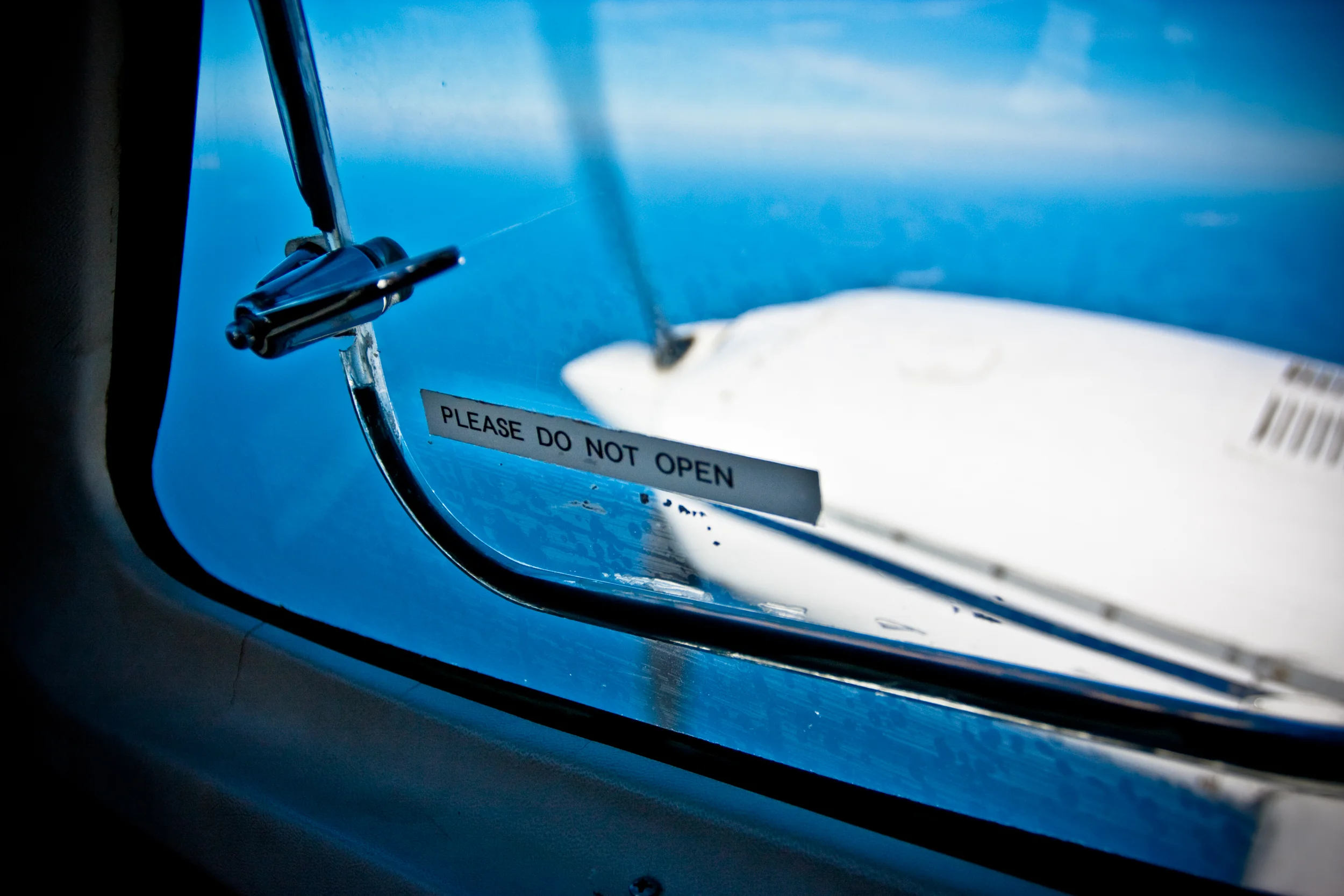 Please do not open sign over a plane window.