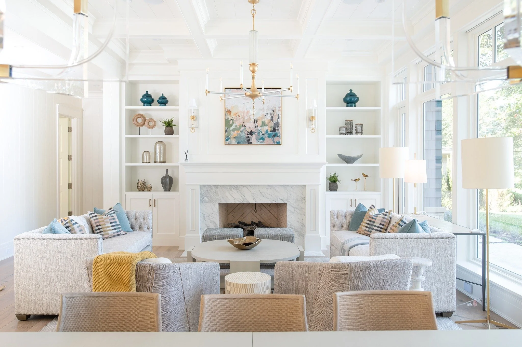 Spring is starting to feel closer when natural light fills a space like this. 

This living room was designed to celebrate it, large windows that invite the sunshine in, paired with playful colors that bring energy, warmth, and a little excitement fo