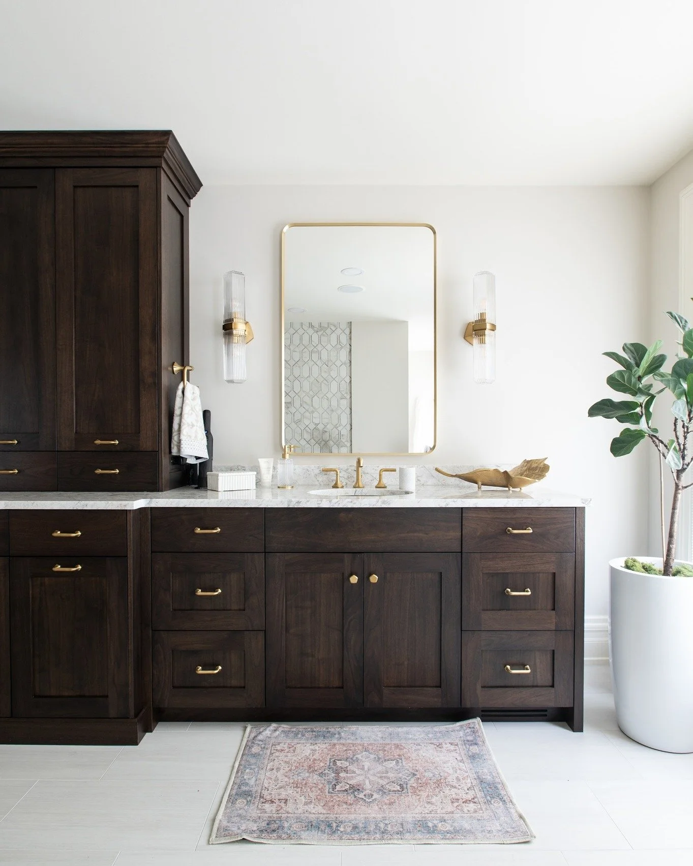 This primary bathroom embraces a rich, sophisticated palette with dark cabinetry that grounds the space and creates a sense of depth. Paired with exquisite tile, layered in texture, pattern, and tone, the result is a space that feels both dramatic an