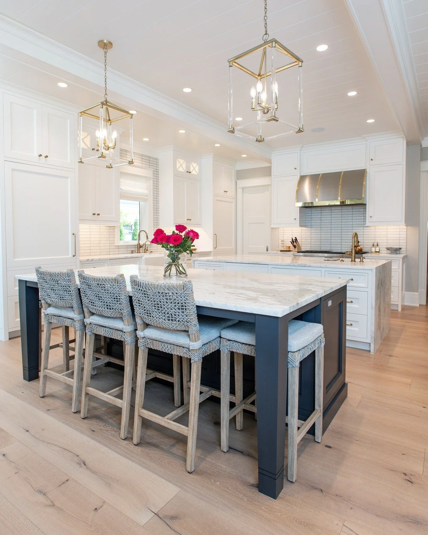 The kitchen at #msblakesidechic features one island that keeps things classic in crisp white, maintaining the airy continuity of the space. The second island introduces a bold, unexpected twist, deep dark blue cabinetry that anchors the room and adds