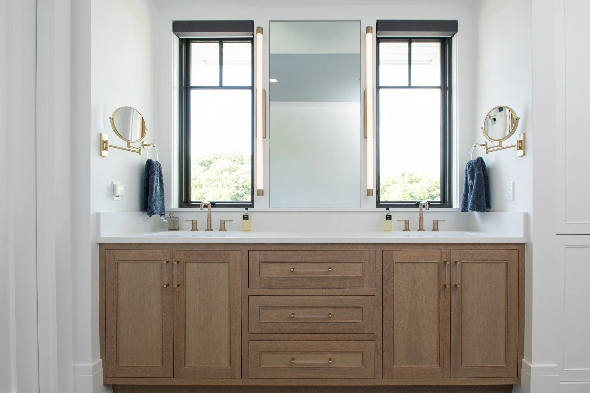 In this primary bathroom, the view was the true centerpiece, so the design was intentionally shaped around it. Rather than treating the vanity wall as a standard focal point, we placed windows directly over the sinks to bring in uninterrupted water v