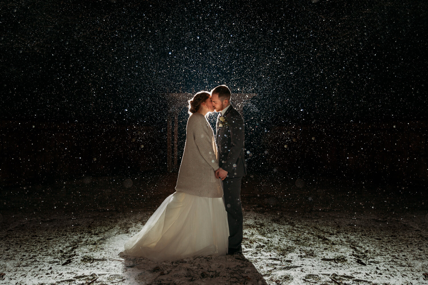 bride-groom-kissing-snow-falling-night-1.jpg