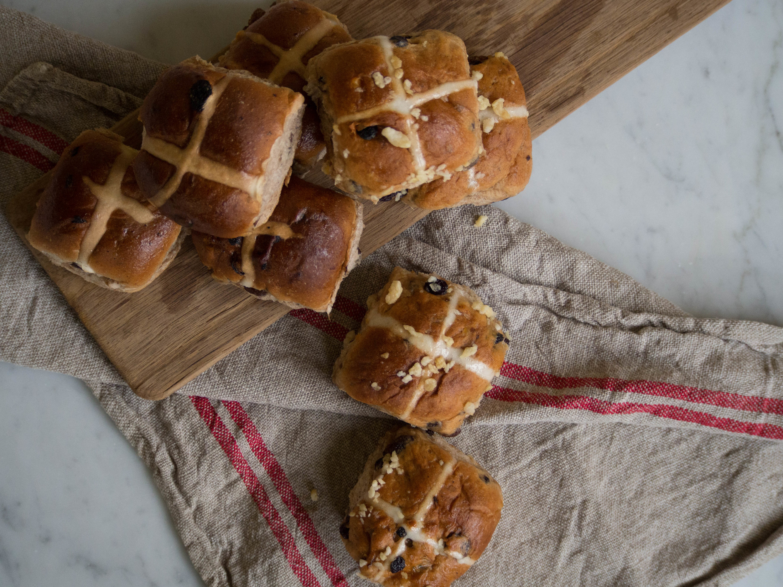 Hot Cross Buns from Baker's Delight (left) and Jamie Oliver's Stem Ginger Hot Cross Buns from Woolworths (right).