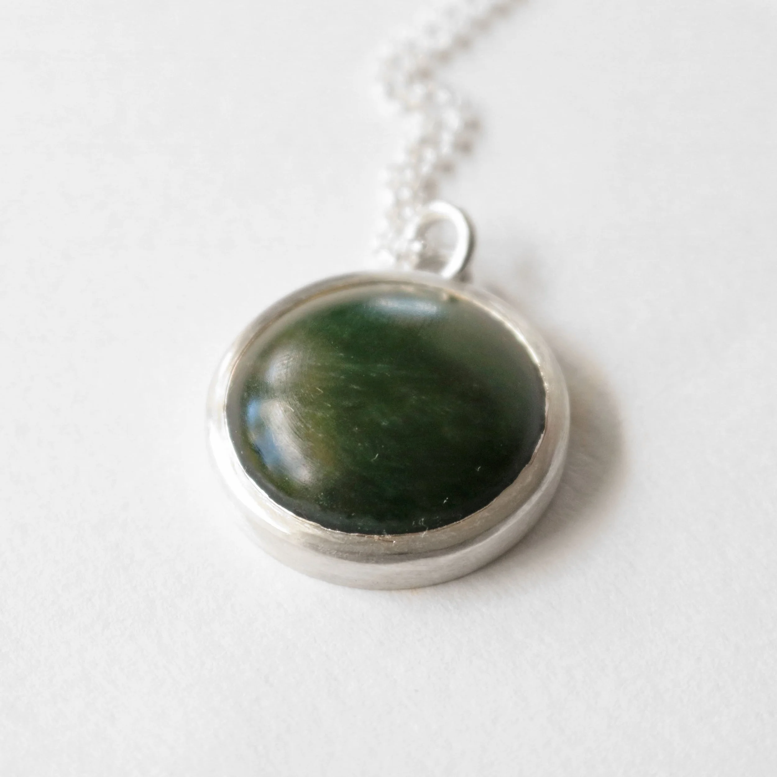 Dark pounamu silver round pendant.jpg