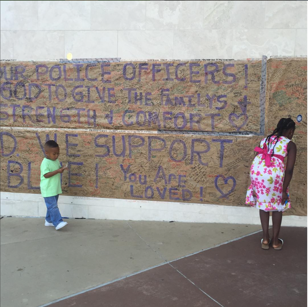   Dallas, TX. This little boy held a police badge sticker and brought it over to his mother. He pulled the sticker off and said, "look mama I'm strong!" I thought about the world this little boy is growing up in, how his young life has already been i