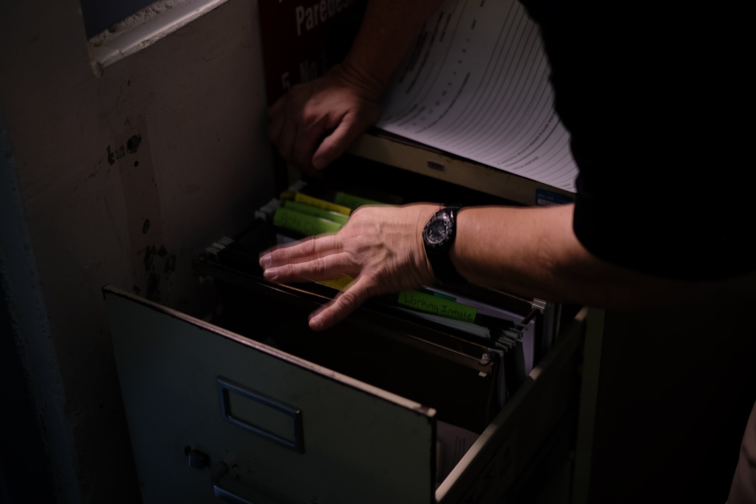  Patterson looks for a commissary sheet in a file cabinet in the "pod" overlooking D and C block, where she spends most of her day. Christmas Day, 2015. 