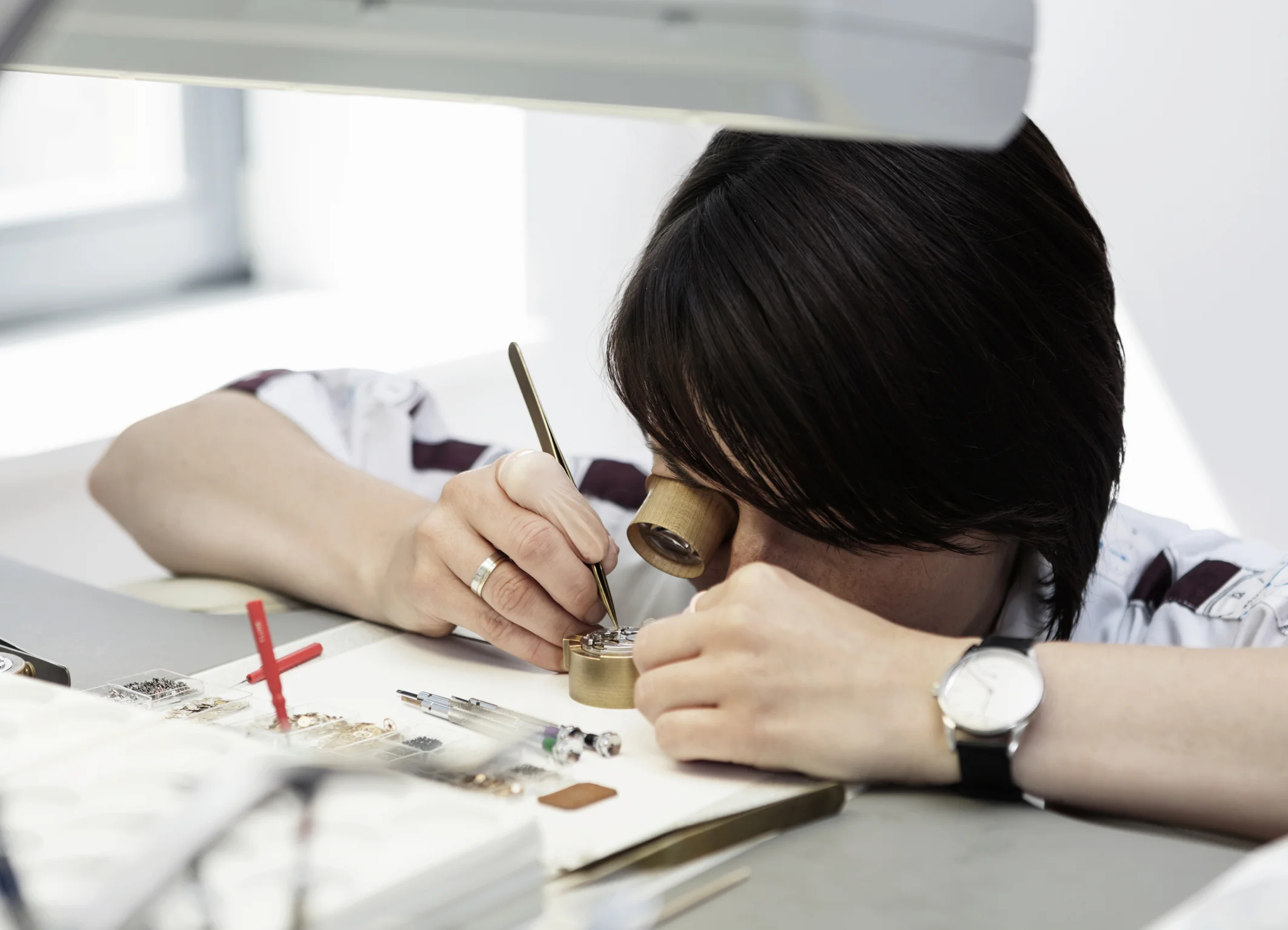 a very patient watchmaker working on a noms caliber. photo courtesy of nomos.