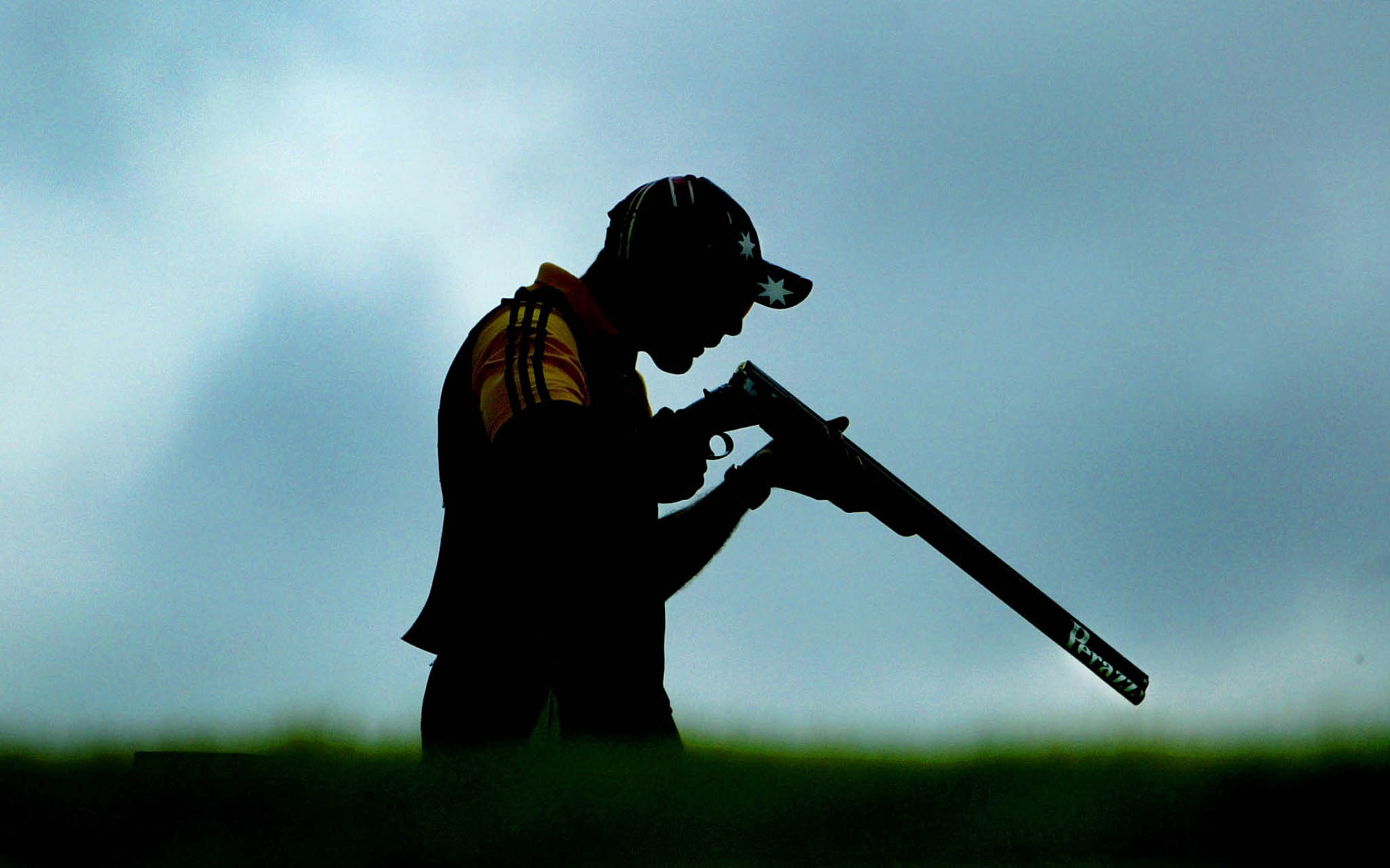 Australian trap shooter Michael Diamond blows down his rifle while competing in the 2002 Commonwealth Games. Diamond won the gold medal and compatriot Adam Vella won the silver medal. Image supplied by Action Images/ Kieran Doherty.