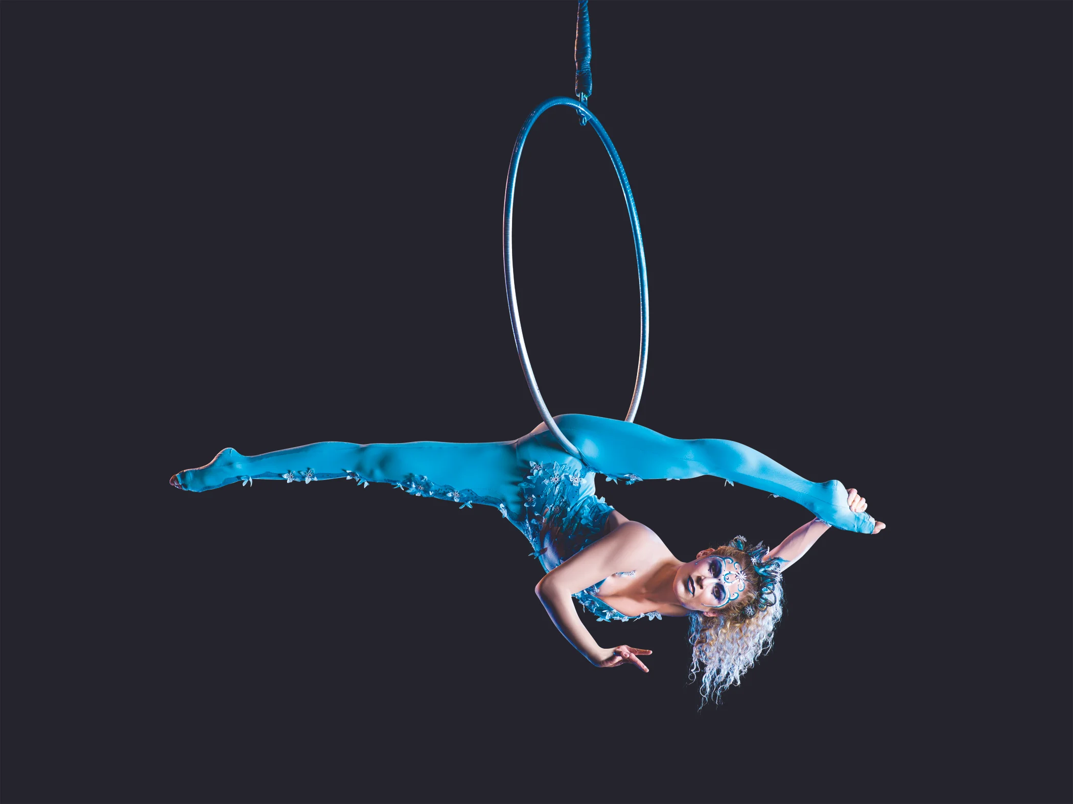 An acrobat performs for Cirque du Soleil, suspended on a cerceau. When gymnasts retire from competition, often at a young age, Cirque offers a continuation of a passion. Image supplied by Cirque du Soleil. 