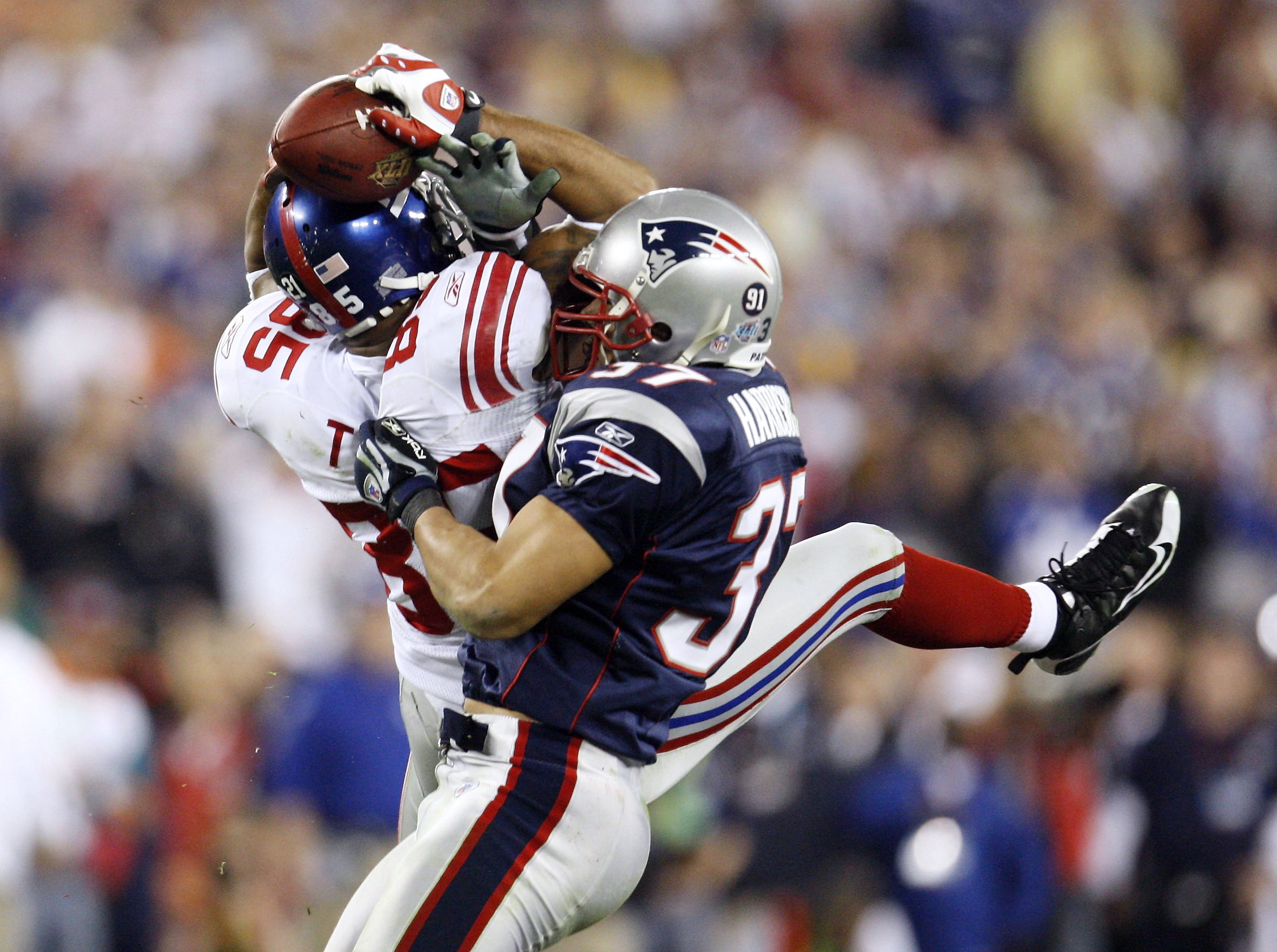 New York Giants receiver David Tyree (L) hauls in a Eli Manning (not pictured) pass last in the fourth quarter for a first down during the NFL's Super Bowl XLII. This victory is regarded as one of the greatest upsets of all time as the Patriots were chasing a perfect season and were expected to win the final comfortably. Image supplied by Action Images/ Shaun Best.