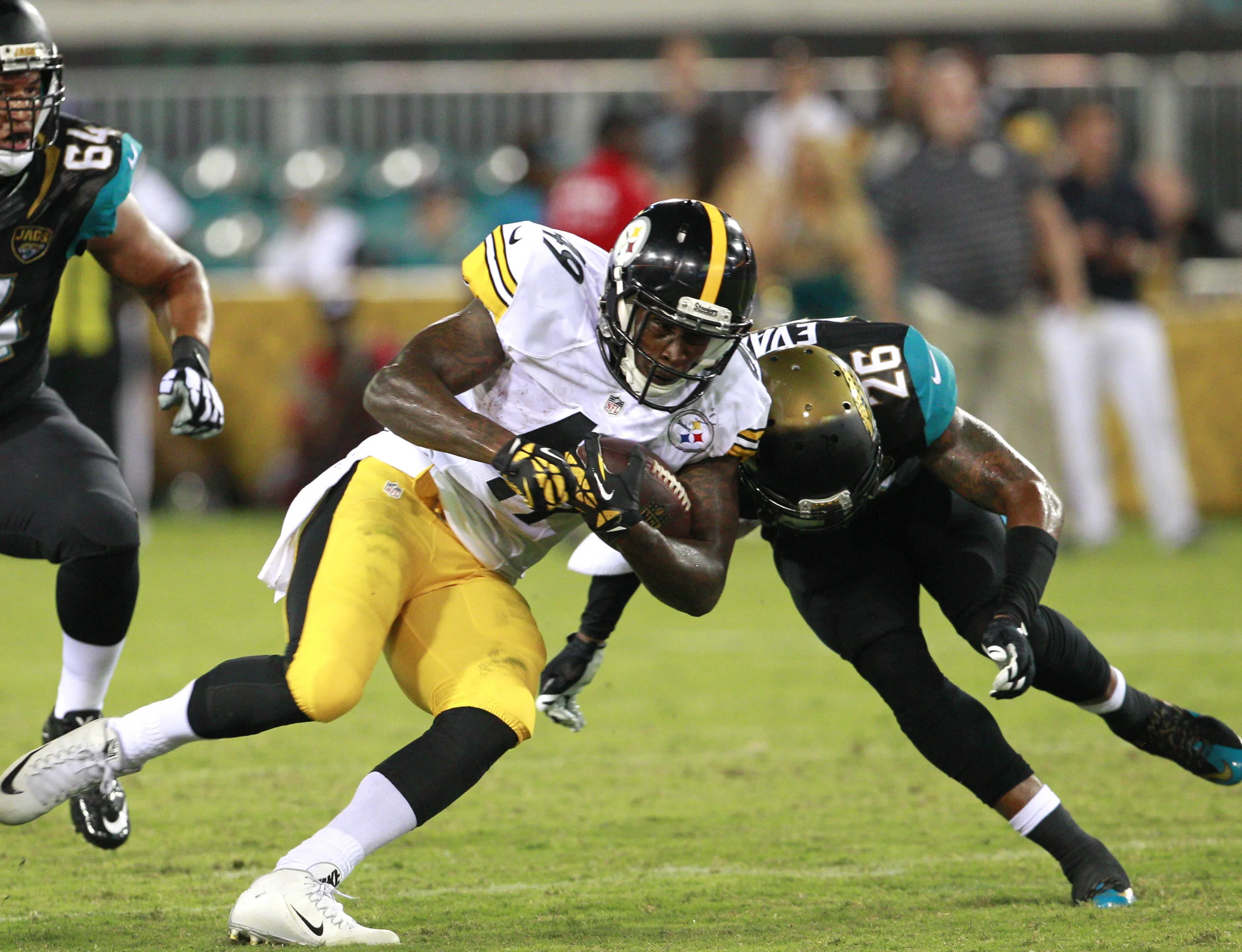 Pittsburgh Steelers running back Jawon Chisholm (49) runs as Jacksonville Jaguars free safety Josh Evans (26) makes a tackle during the second half of a preseason NFL football game. Notice how the tackler is leading with his head. This technique has been directly linked to concussion injuries and is why the NFL is attempting to make the chop tackle technique more prevalent in the sport. Image supplied by Action Images/ Reinhold Matay.