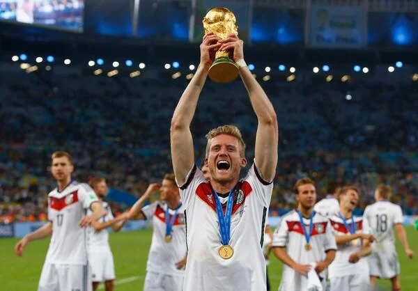 Andre Schurrle celebrates with the FIFA World Cup trophy after Germany defeated Argentina in the 2014 World Cup. 