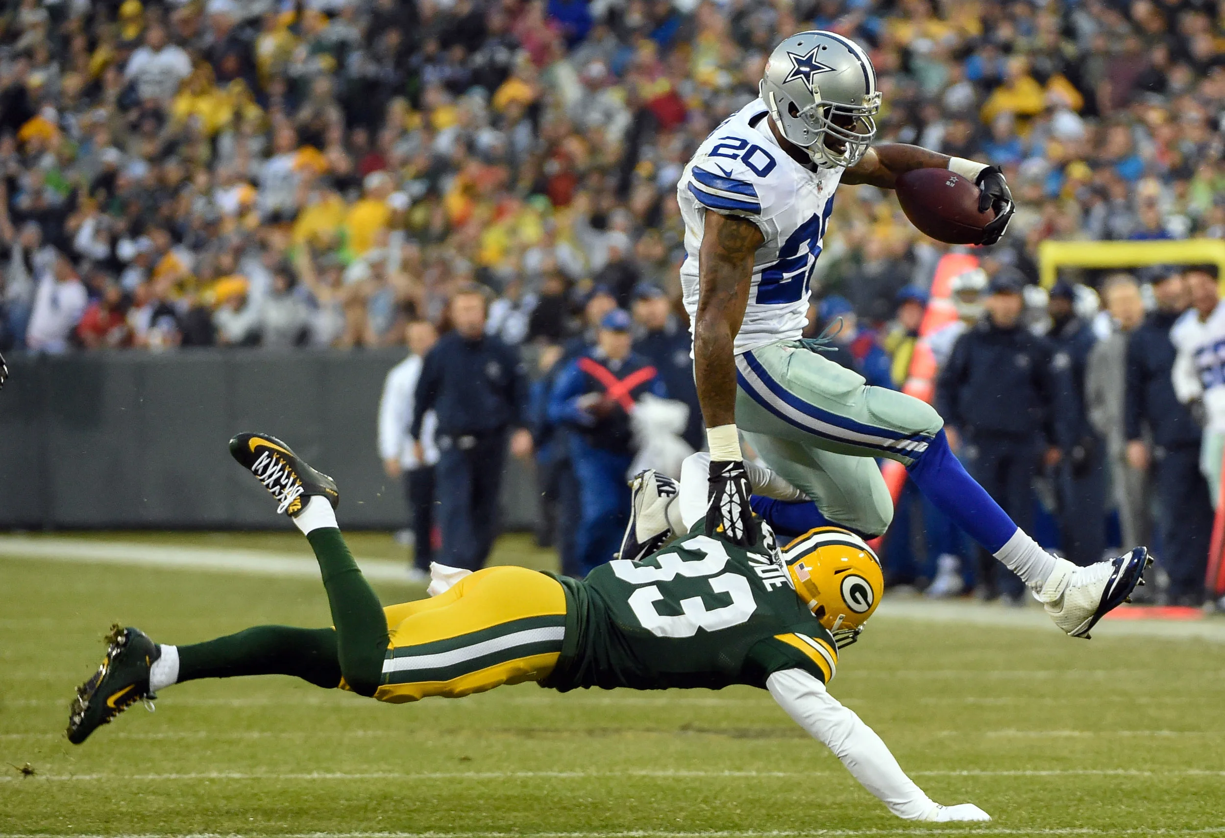 Darren McFadden (20), running back for the Dallas Cowboys, jumps over Green Bay Packers safety Micah Hyde (33). McFadden, like most elite athletes, is at his best when not over thinking his movements. Image supplied by Action Images / Benny Sieu.