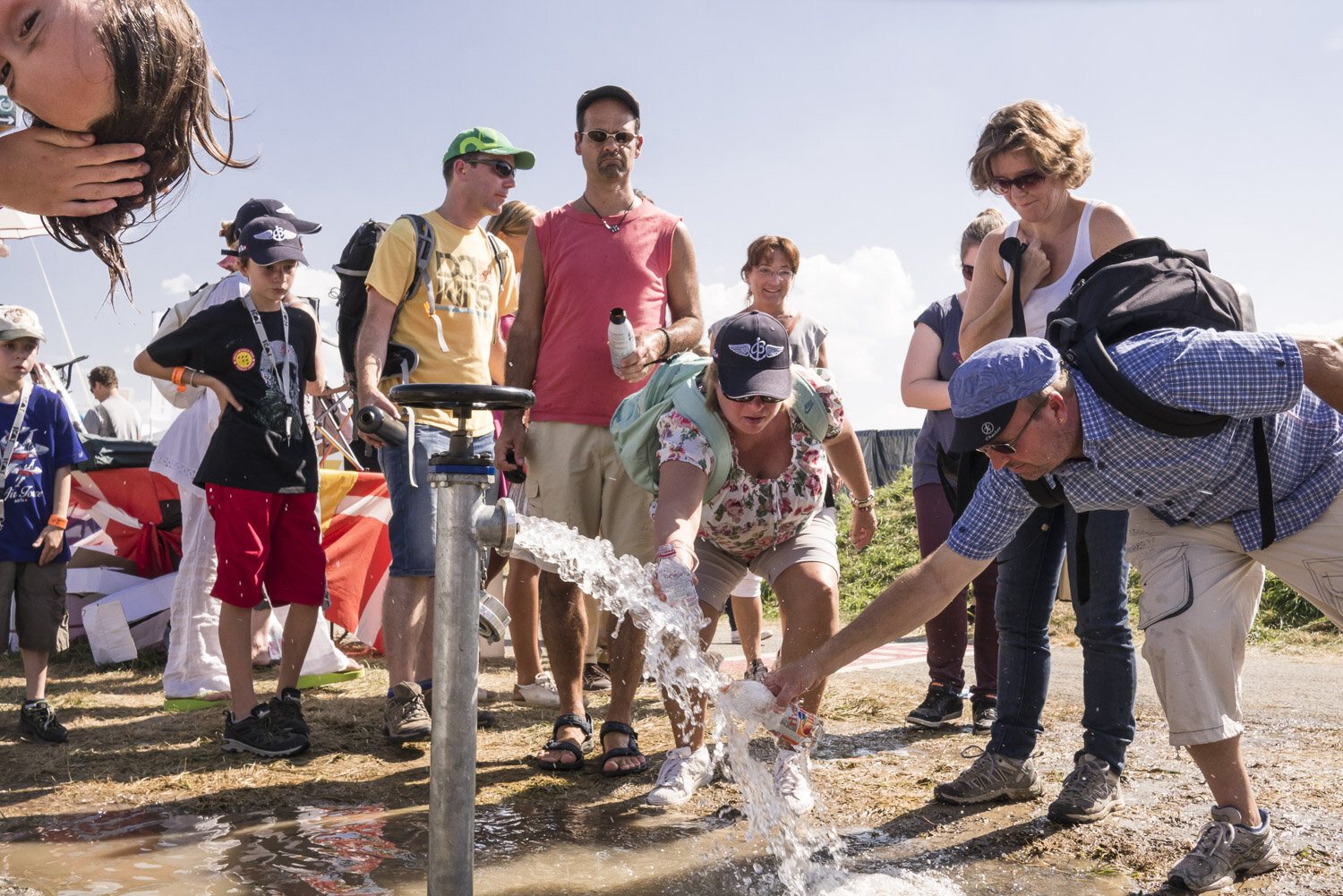 Public populaire se rafraichit à un point d'eau lors du meeting AIR14