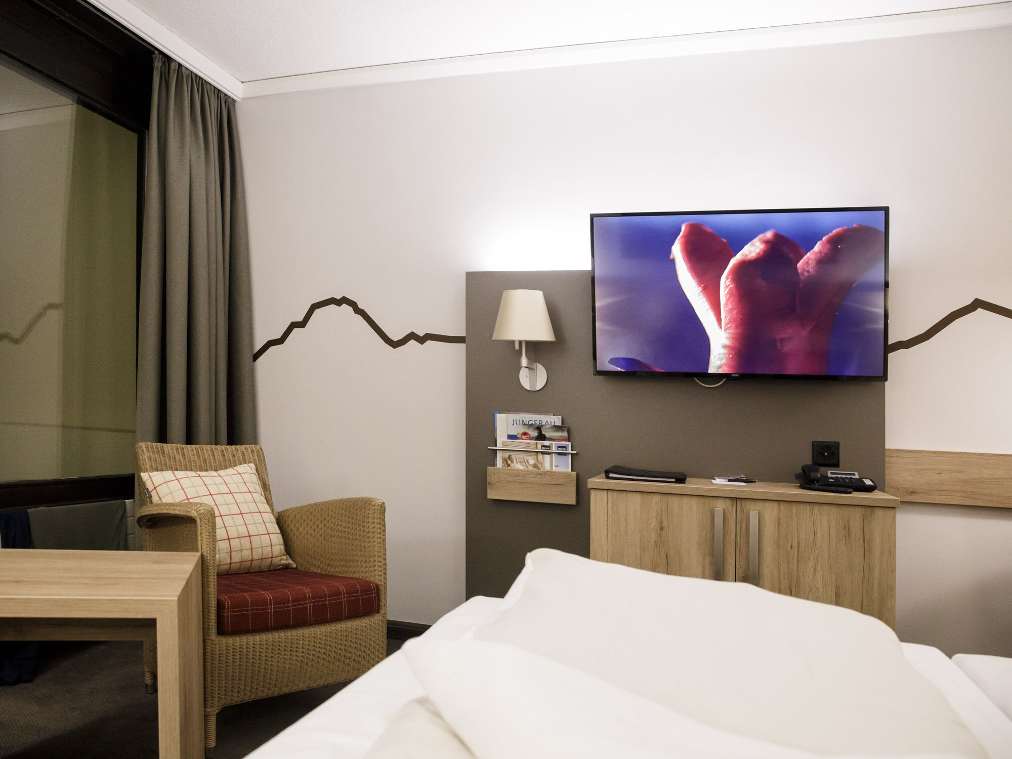 Hotel room with a TV screen showing an advertisment for Cervelas